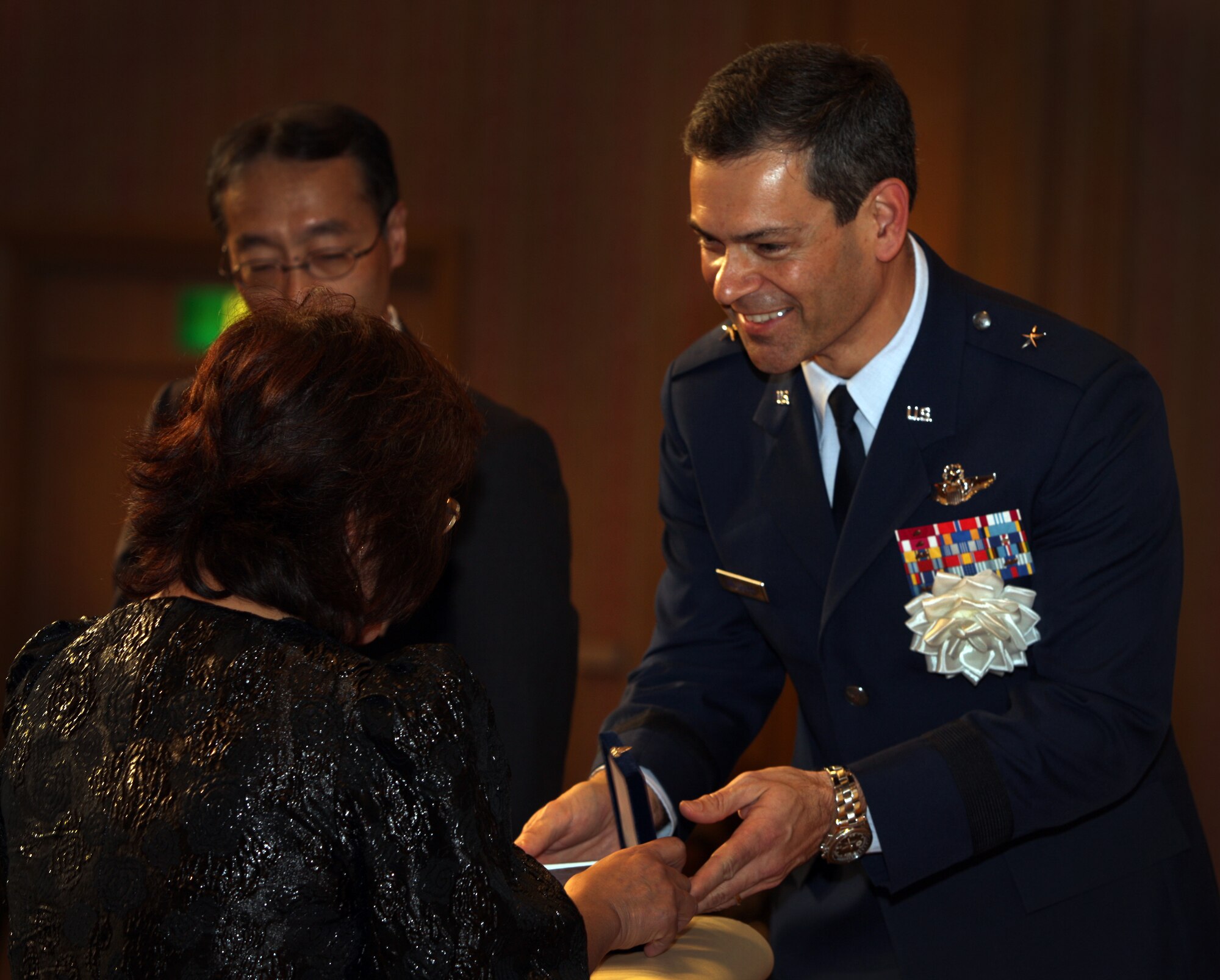 Brig. Gen. Ken Wilsbach, 18th Wing commander, gives an award to an Okinawan for her years of service to American forces on Okinawa at a length of service ceremony at the Laguna Garden Hotel in Ginowan Oct. 21. A local working at Kadena’s finance office was honored for her 42 years of service. (U.S. Air Force Photo/Charles "Chip" Steitz) 