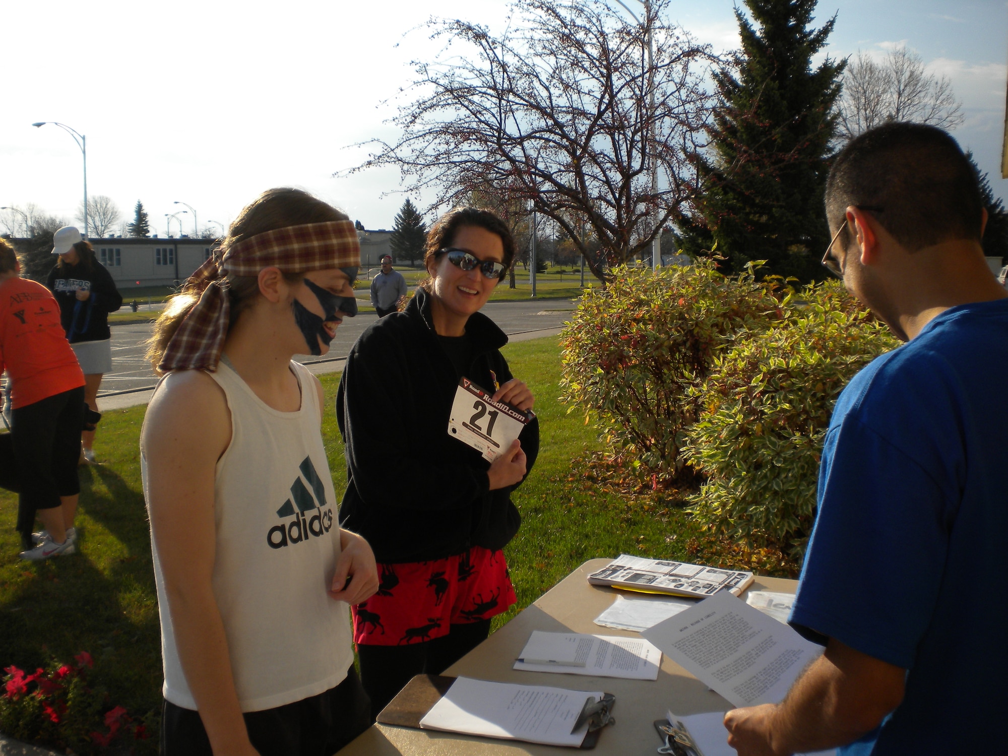 Col. Nina Armagno, 21st Operations Group commander (center), and 2nd Lt. Abigail Coover, 10th SWS crew commander (left), register for the 10K run at Cavalier Air Force Station. This was the first year the 10th SWS held the fun run, and they plan to make it an annual event. (U.S. Air Force photo/2nd Lt. Francisco Vazquez)