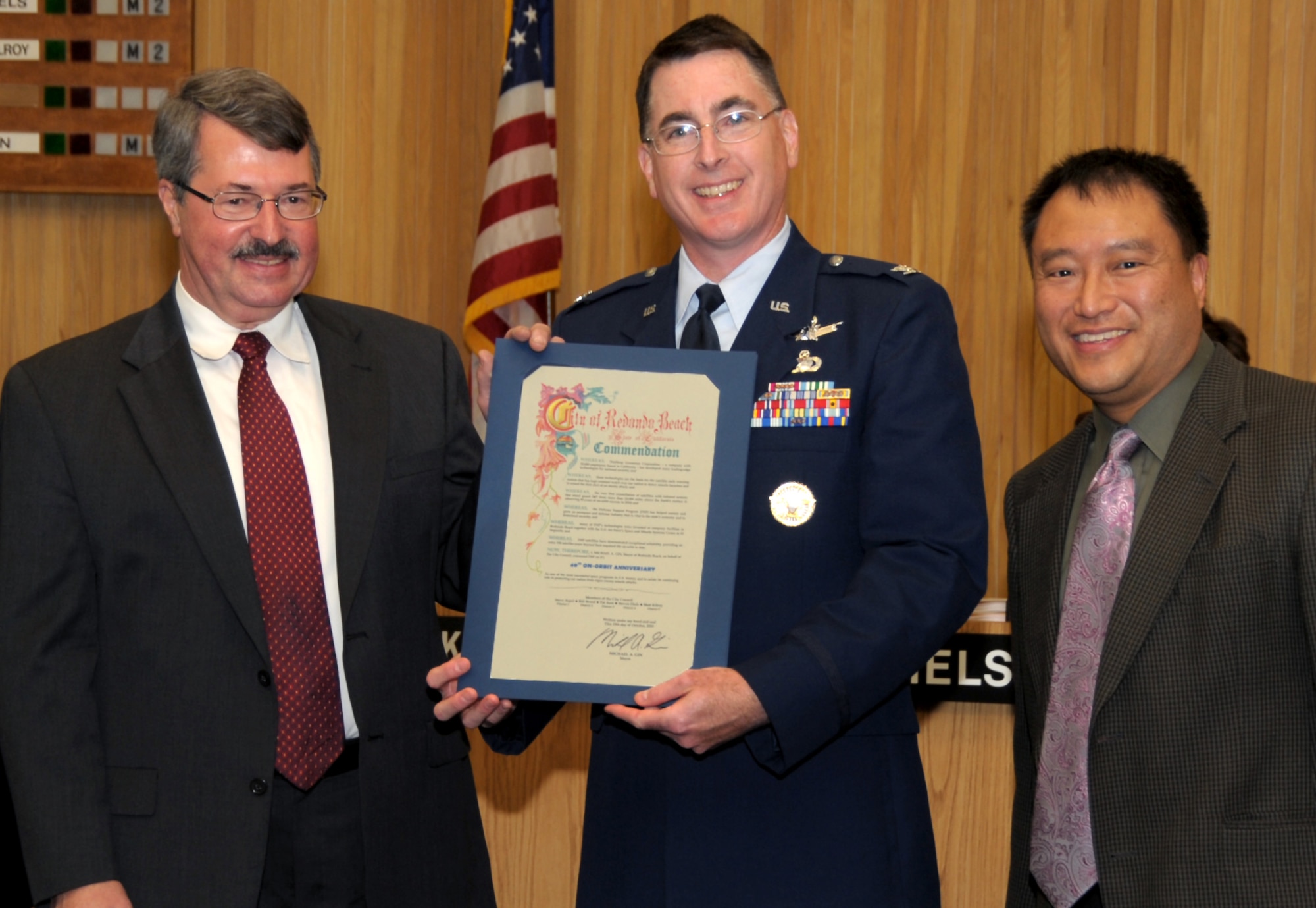 Redondo Beach Mayor Mike Gin (pictured far right) presents a proclamation to Col. Scott Larrimore, Space Based Infrared Systems Wing, and John Kravec, Northrop Grumman Space Systems Division DSP program manager, at the Redondo Beach City Council meeting, Oct.  19.  The proclamation recognized the 40th Anniversary of the Defense Support Program satellites, which were built locally in Redondo Beach.  DSP satellites use infrared sensors to detect heat from missile and booster plumes against the Earth's background. The23rd and last DSP satellite was launched in December 2007. (Photo by Joe Juarez)