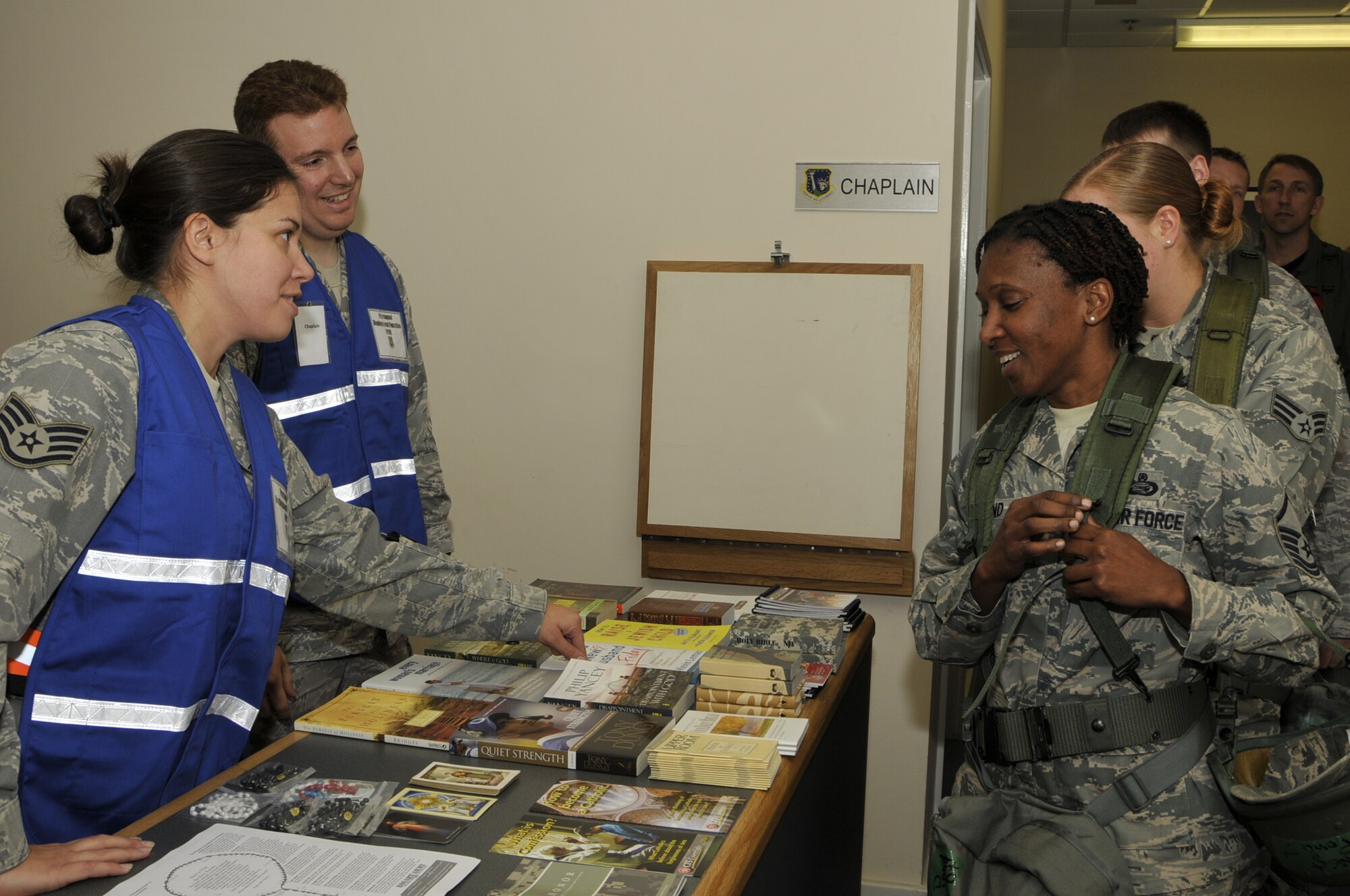 ROYAL AIR FORCE LAKENHEATH, England--Master Sgt. Paula Pond, (right) 48th Force Support Squadron NCO In-Charge of customer support, stops at the Chaplain station and is greeted by Staff Sgt. Theresa Allen, 48th Fighter Wing chaplain assistant, (left) and Capt. Mathew Glaros, 48th Fighter Wing chaplain (far left), while processing the pre-deployment line during an operational readiness inspection deployment readiness center Oct. 25. Sergeant Pond is deploying to Saxon Air Base, Anglia. (U.S. Air Force photo/Airman 1st Tiffany Deuel)
