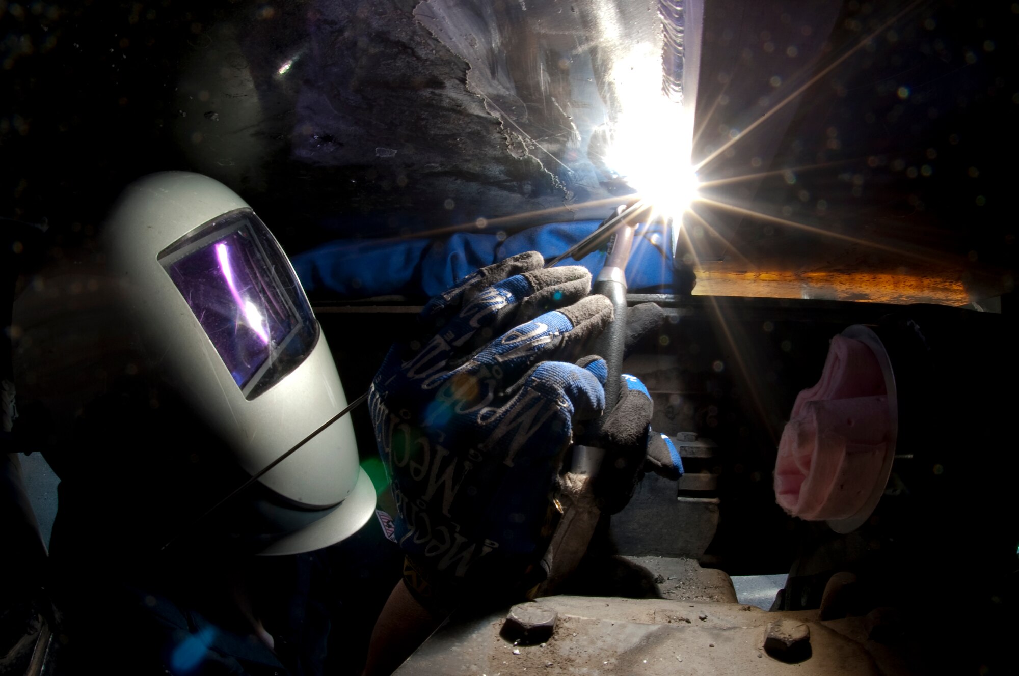 HOLLOMAN AIR FORCE BASE, N.M. -- Tech. Sgt. Daniel Fraga, master welder for the 49th Maintenance Squadron, welds a crack on the undercarriage of an R-11 fuel truck Oct. 14, 2010. Sergeant Fraga used welding filler wire to add to the molten pool created by the welding process. This welding task began when the Non-Destructive Inspection Flight discovered a six-inch crack in the fuel tank and the task was the first to ever be attempted at Holloman. The Metals Technology Flight took precautions in planning for the project, starting with airing out the fuel tank for over a month. They used a non-reactive gas while welding to prevent the tank from exploding. Firefighters from the 49th Civil Engineer Squadron inspected the area and stayed on site during the project to ensure safety. (U.S. Air Force photo by Airman 1st Class Joshua Turner/Released)