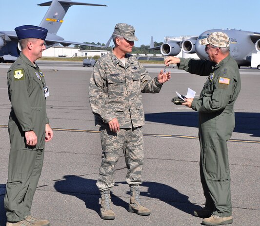 Major General Martin Mazick (right), vice commander for the Air Force Reserve Command, presents Colonel Steven Chapman (center), commander of the 315th Airlift Wing, the symbolic keys to the newest C-17 arriving at Joint Base Charleston.  Maj. Gen. Mazick and Col. Chapman are joined by Col. John Wood, commander of the 437th Airlift Wing (U.S. Air Force photo/Staff Sgt. Shane Ellis)