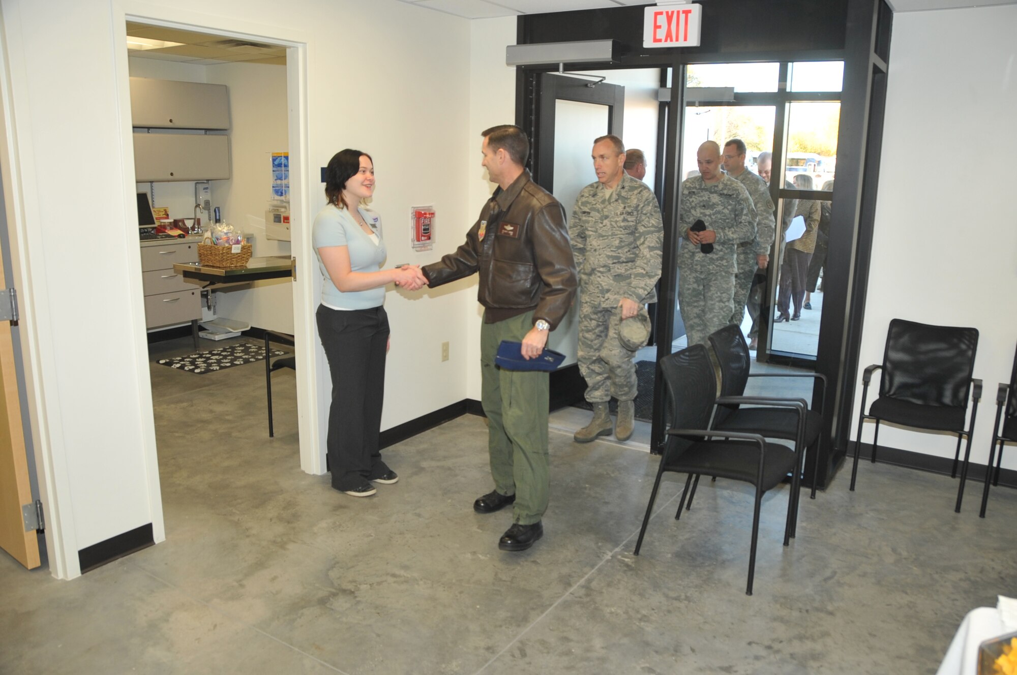 OFFUTT AIR FORCE BASE, Neb. -- Lara Mohammed, veterinarian technician here, greets 55th Wing Vice Commander Col. William P. Jensen and other Offutt leaders as they enter the new Offutt Veterinarian Clinic Oct. 20 after a ribbon cutting ceremony.  The new clinic is 40-percent larger than the old facility and increases efficiencies for the entire vet staff of six personnel. U.S. Air Force photo by Jeff Gates