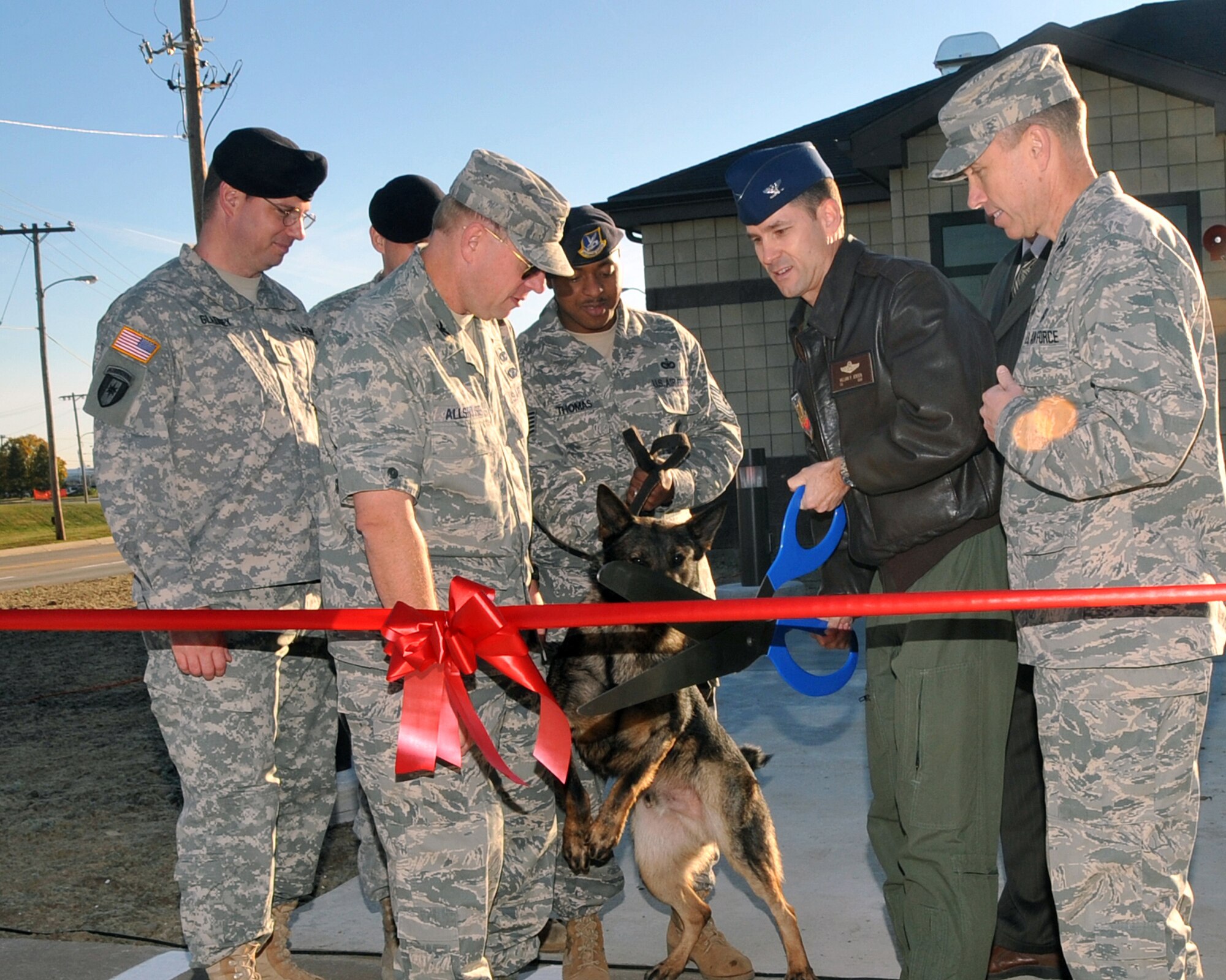 OFFUTT AIR FORCE BASE, Neb. - (From left) U.S. Army Capt.  Jason Gladney, Offutt veterinarian; Col. Michael Allshouse, 55th Mission Support Group commander; Tech. Sgt. Williams Thomas with Military Working Dog Nero, 55th Security Forces Squadron; Col.  William Jensen, 55th Wing vice commander and Col. Patrick Dawson, 55th Medical Group commander, prepare to cut the ribbon to officially open the new veterinary clinic here Oct. 20. U.S. Air Force photo by Jeff W. Gates.