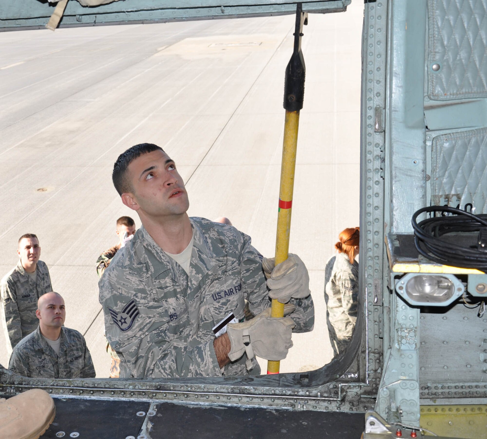 WRIGHT-PATTERSON AIR FORCE BASE, Ohio – Staff Sgt. Hugh Gibbs, 445th Civil Engineer Squadron firefighter, runs through an aircraft emergency entrance training scenario with his fellow firefighters by securing the cargo door of a C-5 Galaxy during the Oct. 17 unit training assembly. (U.S. Air Force photo/Senior Airman Mikhail Berlin)
