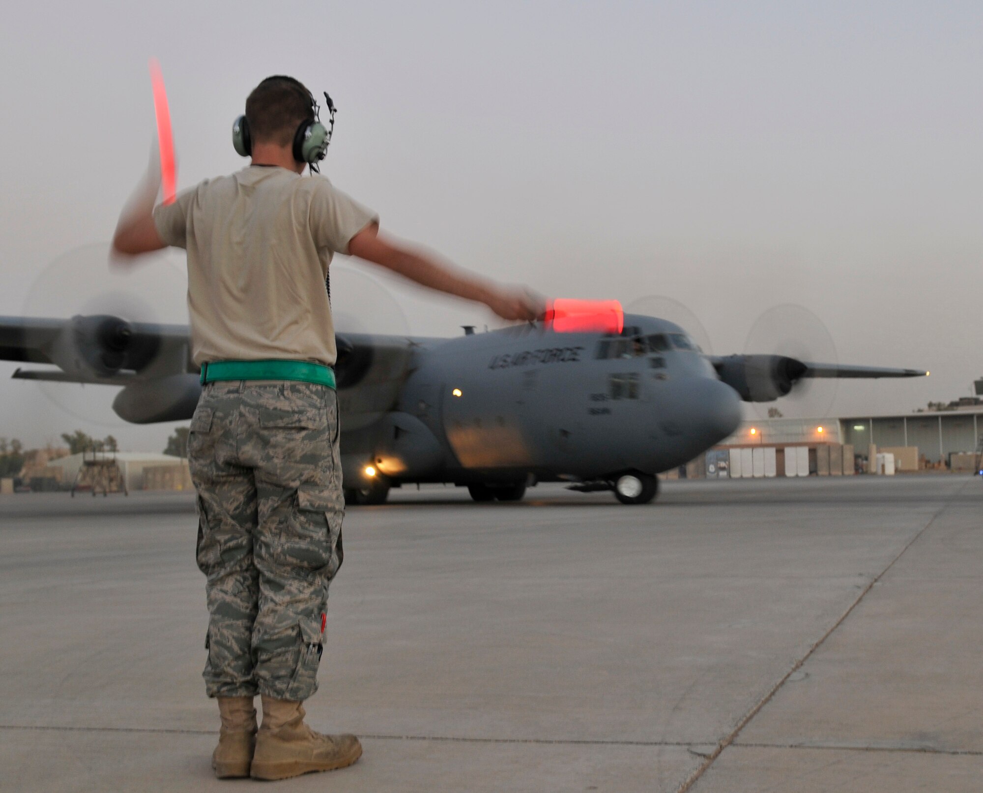 Senior Airman Ryan Berry, 777th Expeditionary Aircraft Maintenance Unit crew chief, marshals a C-130 Hercules from its parking spot for a mission Oct. 19, 2010, Joint Base Balad, Iraq.  Airmen marshal aircraft from their parking spots to ensure the aircraft doesn’t collide with equipment on the flightline that the pilot can’t see from the cockpit. Airman Berry is a native of Astoria, Ore. deployed from Little Rock Air Force Base, Ark. (U.S. Air Force photo/Tech. Sgt. Phillip Butterfield)