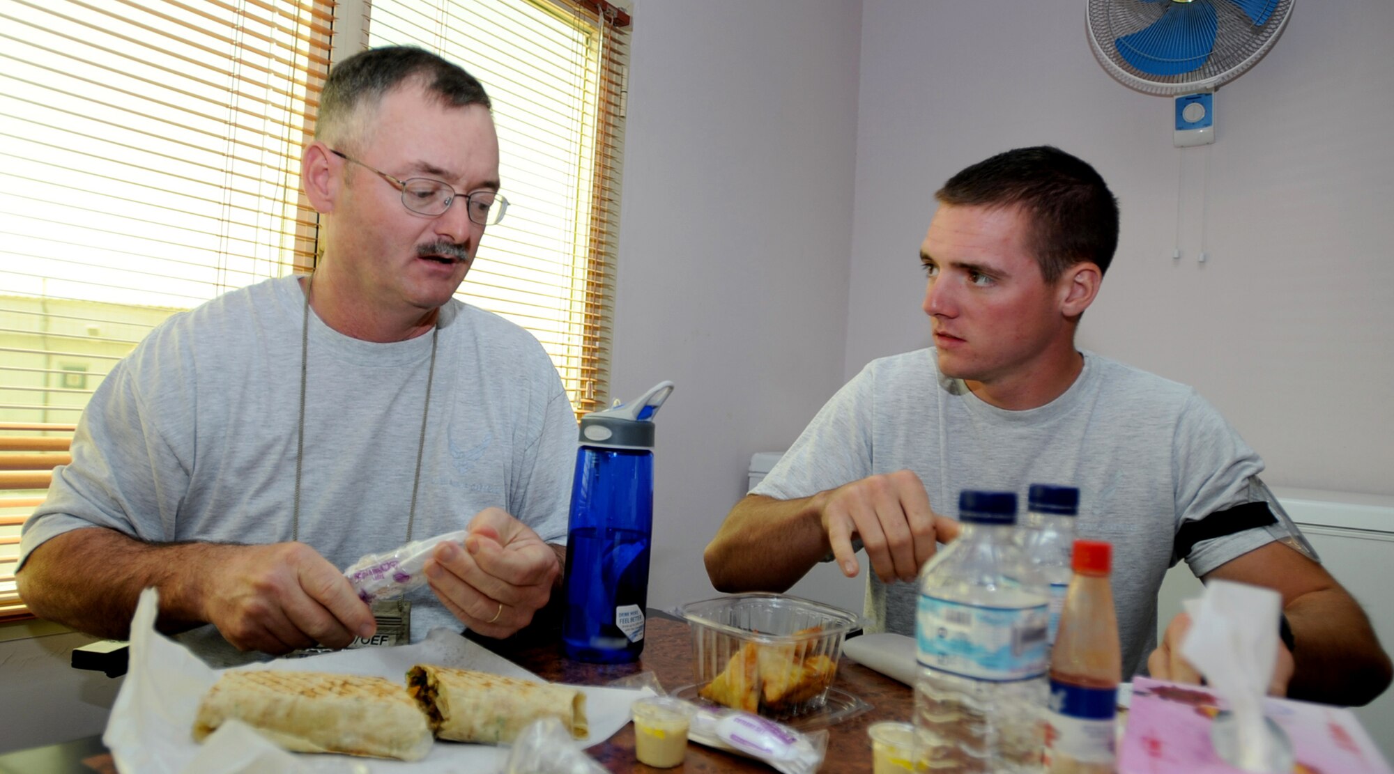 SOUTHWEST ASIA - Senior Master Sgt. Robert Gunther and Airman 1st Class Robert Gunther Jr., a father and son deployed here from the Illinois Air National
Guard, enjoy a meal together at an undisclosed air base Oct. 24. Sergeant
Gunther, first sergeant for the 386th Expeditionary Civil Engineer Squadron,
and Airman Gunther, an electrician in the same unit, often spend off-duty
time together when not working. (U.S. Air Force photo by Senior Airman Laura
Turner)
