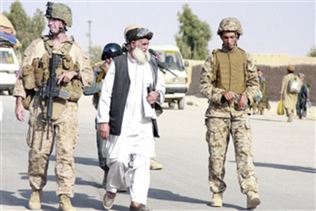 Ezatullah Mujahid (2nd from right), the Sangin district governor, walks with U.S. Marines assigned to Police Mentoring Team 1, 3rd Battalion, 5th Marines, Regimental Combat Team 2, and a civil affairs team during a patrol in partnership with Afghan National Police through the northern bazaar in Sangin valley, Afghanistan, on Oct. 13, 2010.  The battalion is conducting counter insurgency operations in partnership with the International Security Assistance Forces.  
