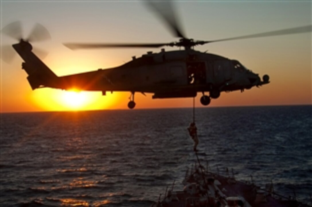 Explosive ordnance disposal team members assigned to the Enterprise Carrier Strike Group, fast-rope onto the deck of the Arleigh Burke-class guided-missile destroyer USS Bulkeley from a SH-60 Sea Hawk helicopter in the Atlantic Ocean, Oct. 21, 2010. The Enterprise Carrier Strike Group is conducting a Composite Training Unit Exercise to prepare for an upcoming deployment.