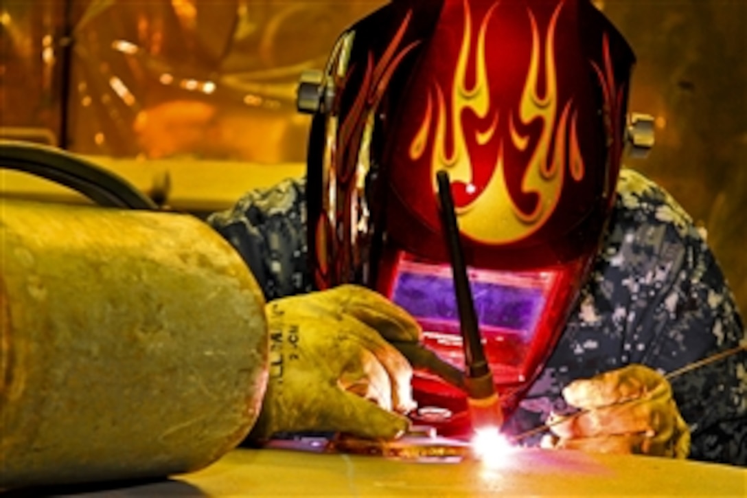 U.S. Navy Petty Officer 2nd Class Dustin Roswell welds the edge of a watertight door at Northrop Grumman's Light Industrial Facility warehouse in Newport News, Va., Oct. 21, 2010. Roswell and his team have refurbished more than 80 watertight doors within a five-month period. Roswell is assigned to the aircraft carrier USS Theodore Roosevelt, which is undergoing an overhaul. 