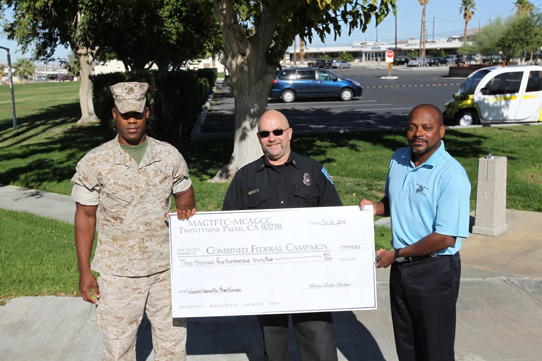 [From left] Lt. Col. James McArthur, the assistant chief of staff for G-3, and Combat Center fire chief Randy Leaser, present a check of $3,435.82 to Allen Hyde, the center’s Combined Federal Campaign coordinator, Oct. 26, 2010 at the base flag pole. The money was raised at the fire department’s annual chili lunch and G-3’s chili cook-off.::r::::n::