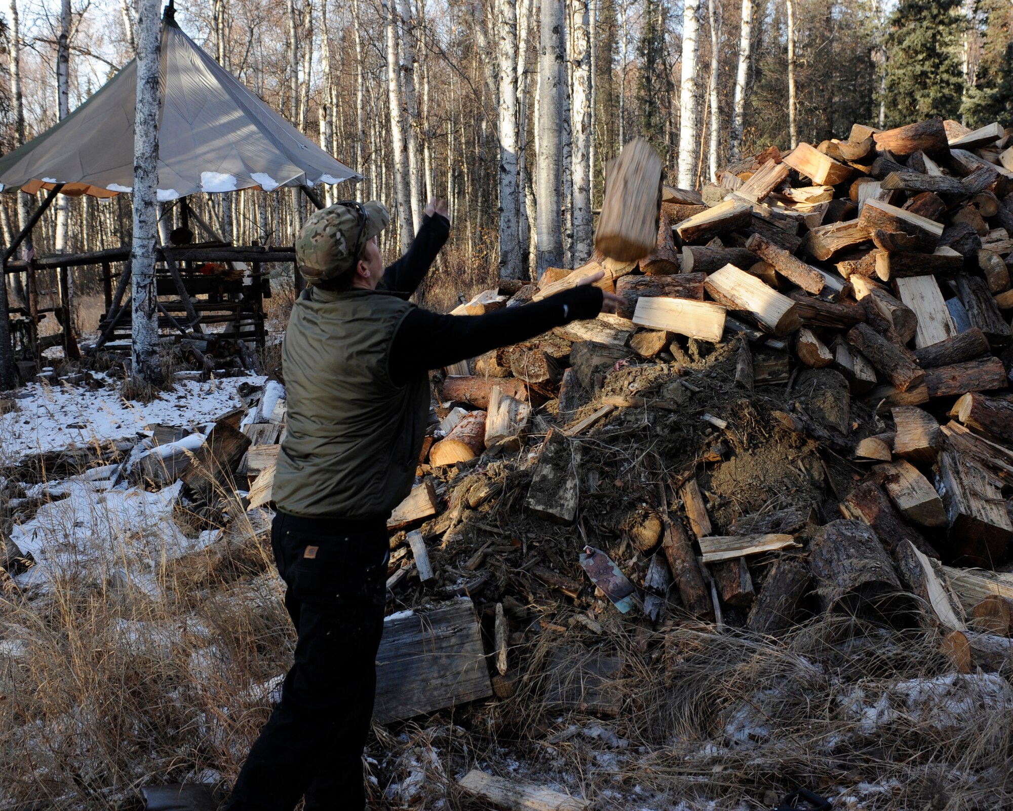 Senior Airman Broc Allen throws wood onto a pile Oct. 25, 2010, Eielson Air Force Base, Alaska. Wood is used by the Cool School to support survival training during frigid winter months. Airman Allen is a survival, evasion, resistance, escape specialist assigned to Detachment 1, 66 Training Squadron. (U.S. Air Force photo/Senior Airman Willard E. Grande II)