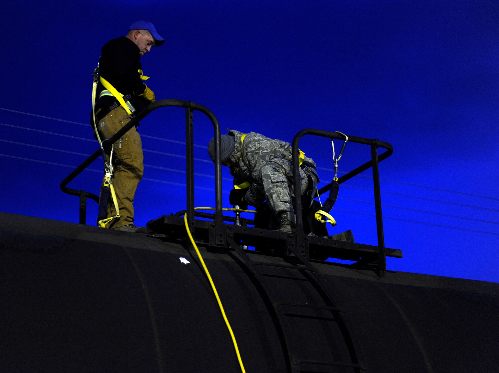 Airman 1st Class Jeffery LeBeau receives training from a governemnt contractor while opening a fuel hatch Oct. 25, 2010, Eielson Air Force Base, Alaska. Airman LeBeau was training on processing received railcars. Airman LeBeau is a fuels technician assigned to the 354th Logistics Readiness Squadron. (U.S. Air Force photo/Senior Airman Willard E. Grande II)