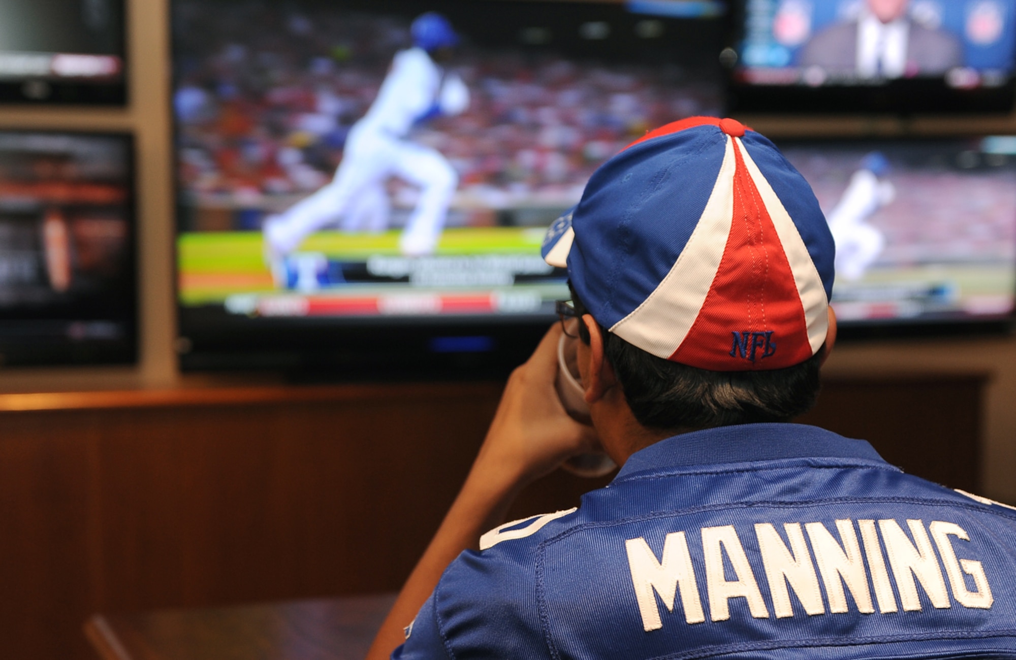 NELLIS AIR FORCE BASE, Nev.--  Anthony Brettler watches ESPN during the Timeout Sports Lounge grand opening Oct. 25 at the Desert Oasis Club. The sports lounge was designed for Airmen of all ranks and provides various options for entertainment.(U.S Air Force Photo / Senior Airman Stephanie Rubi)