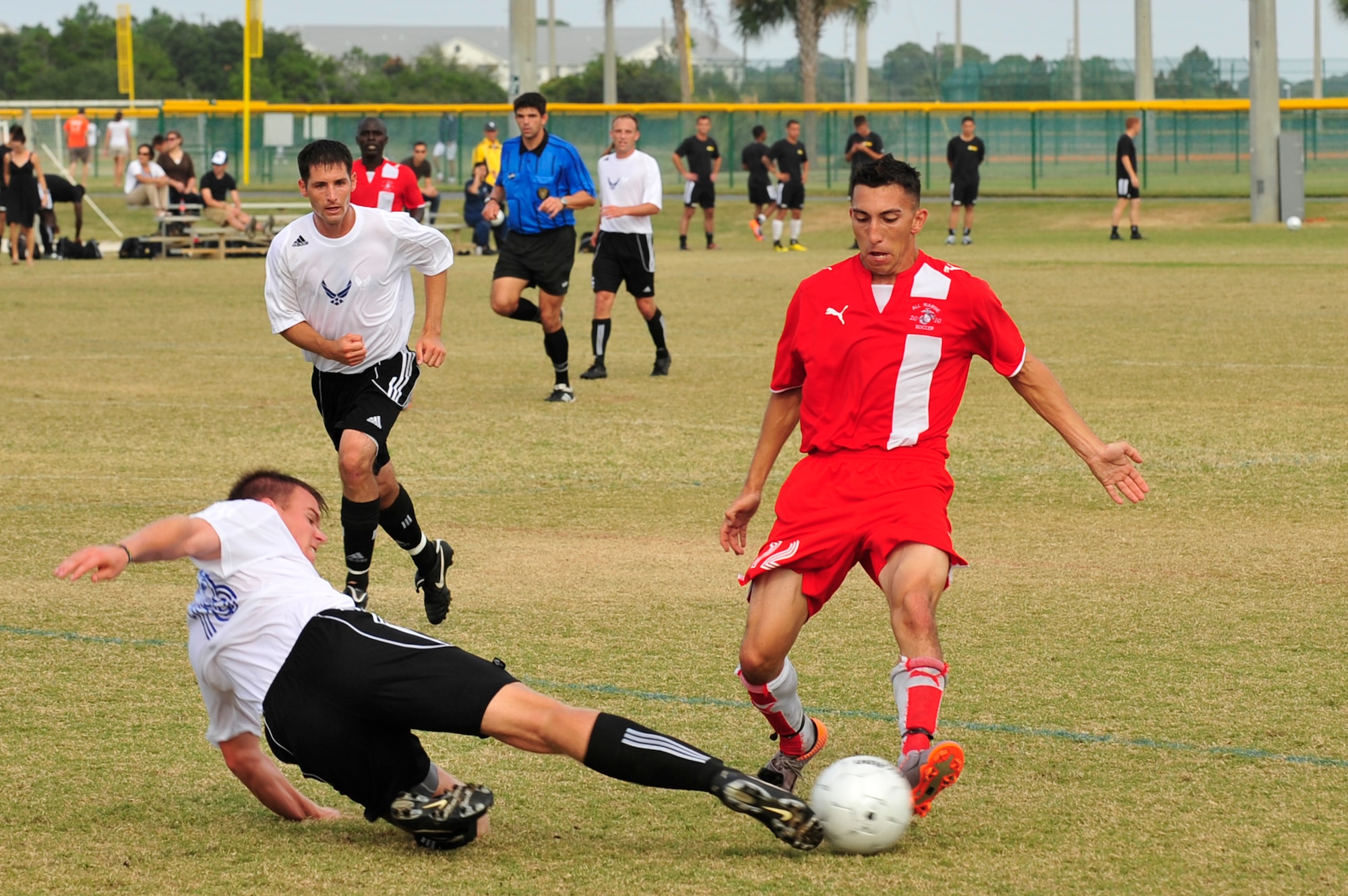U.S. Air Force 2nd Lt. Kevin Rosser, slide tackles U.S. Marine Corps Lance Cpl. Juan Torres for the ball while U.S. Air Force Capt. Jeremiah Kirschman runs in to assist during an Armed Forces Men's Soccer Championship match at Morgan Sports Complex, Destin, Fla., Oct. 24, 2010. The Armed Forces Championships are conducted by the Armed Forces Sports council for the purpose of promoting, understanding, goodwill, and competition among the Armed Services  (DoD Photo by Staff Sgt. Stephanie Jacobs/RELEASED)
