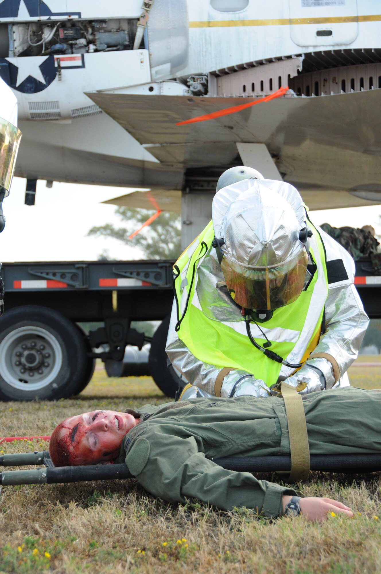 A Keesler firefighter straps Airman Basic Zachary Duerring, a 334th Training Squadron student onto a stretcher to be transported to the triage area in Tuesday's major accident response exercise.  During the exercise a C-130J made a hard landing, lost engine power and crashed into a six-passenger van, coming to rest on the Triangle track north of Alho Manor.  The scenario also included a spill from chemicals on the aircraft, hydraulic fluid and JP-8 fuel.  Three people "died" and 30 were "injured" in the accident, part of this week's Air Education and Training Command Compliance Inspection.  (U.S. Air Force photo by Kemberly Groue)