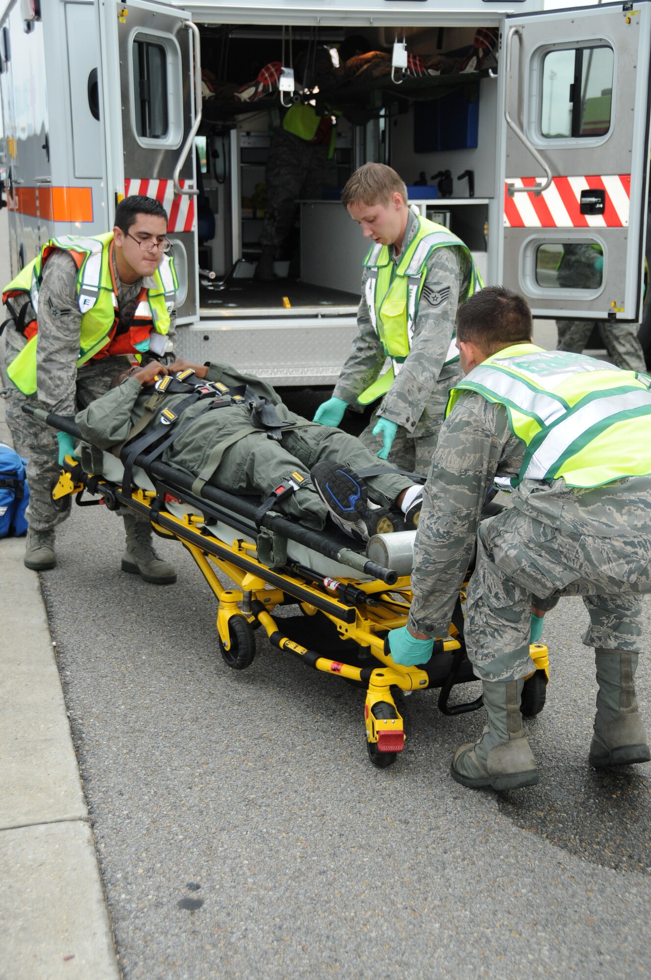 Airman 1st Class James Williams, a 338th Training Squadron student is carefully lifted onto an ambulance by Airman 1st Class Edgar Munoz, Staff Sgt. Monique Toth, and Senior Airman 81st Aerospace Medical Squadron, in Tuesday's major accident response exercise.  During the exercise a C-130J made a hard landing, lost engine power and crashed into a six-passenger van, coming to rest on the Triangle track north of Alho Manor.  The scenario also included a spill from chemicals on the aircraft, hydraulic fluid and JP-8 fuel.  Three people "died" and 30 were "injured" in the accident, part of this week's Air Education and Training Command Compliance Inspection.  (U.S. Air Force photo by Kemberly Groue)