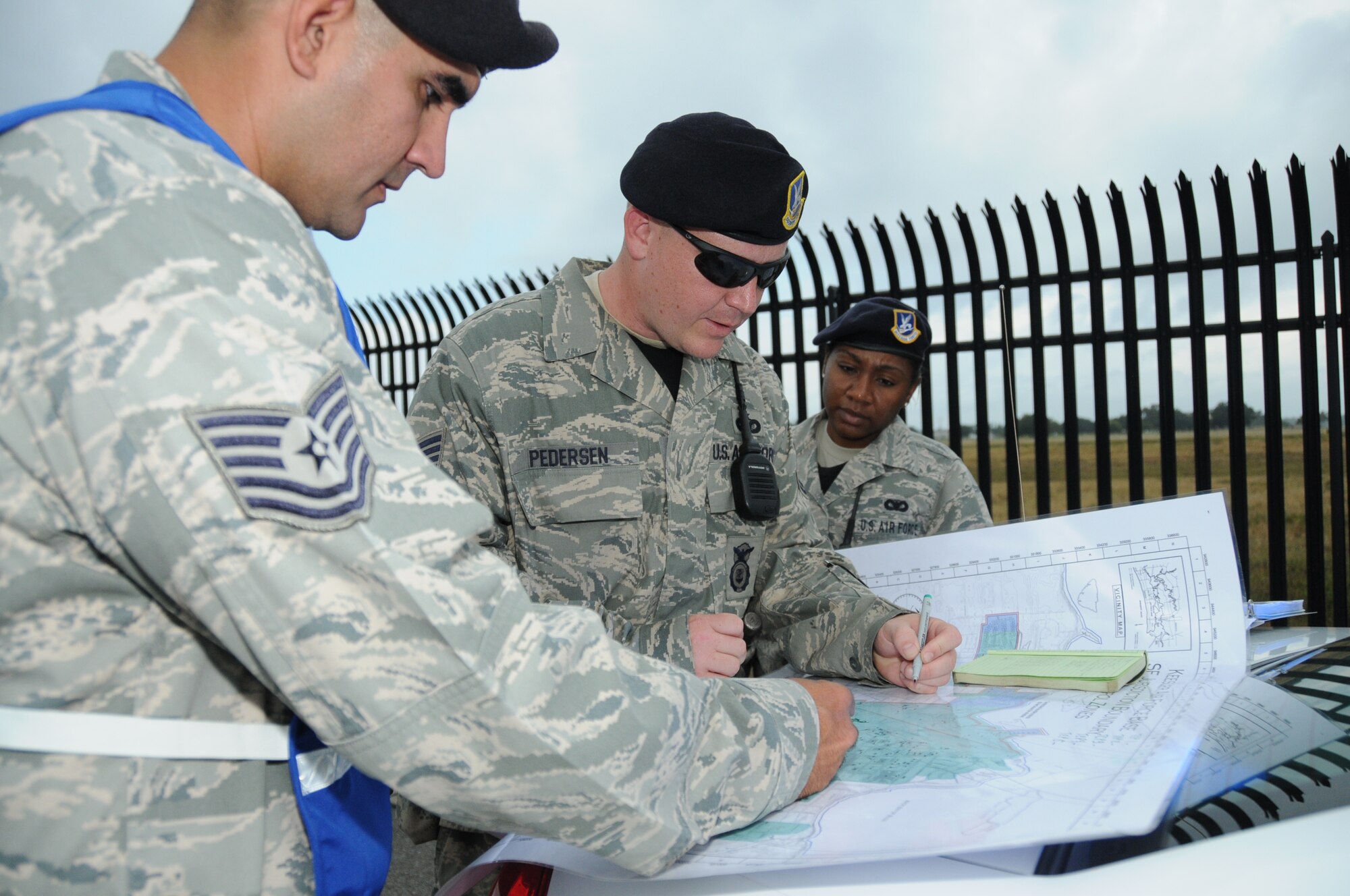 Tech. Sgt. Erik Castro, Tech. Sgt. Chad Pedersen, and Staff Sgt. Wahkina Boyd 81st Security Forces Squadron, view the cordon area in Tuesday's major accident response exercise.  During the exercise a C-130J made a hard landing, lost engine power and crashed into a six-passenger van, coming to rest on the Triangle track north of Alho Manor.  The scenario also included a spill from chemicals on the aircraft, hydraulic fluid and JP-8 fuel.  Three people "died" and 30 were "injured" in the accident, part of this week's Air Education and Training Command Compliance Inspection.  (U.S. Air Force photo by Kemberly Groue)