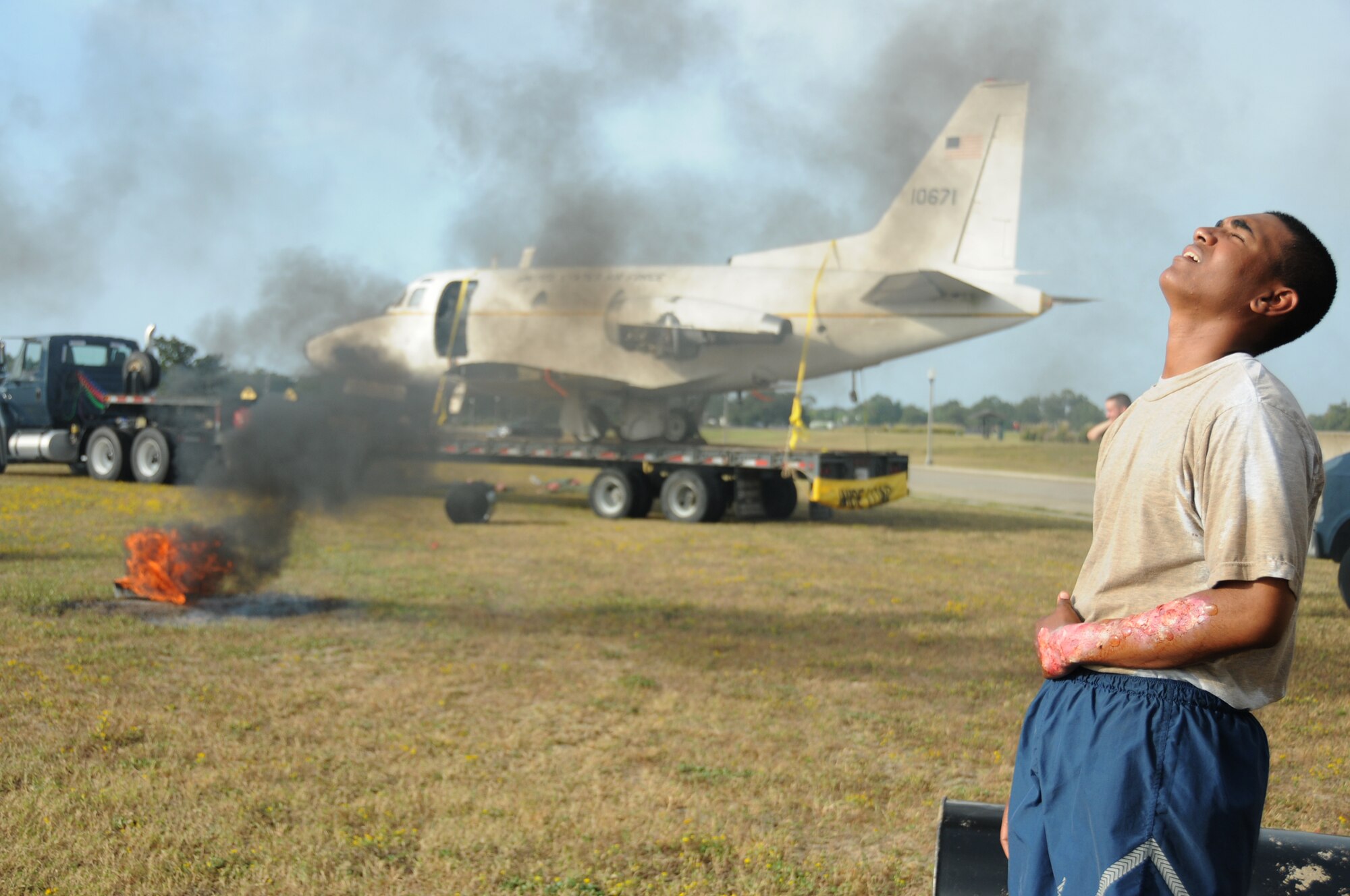 Airman Basic Christopher Hagger, 334th Training Squadron student yells for help in Tuesday's major accident response exercise.  During the exercise a C-130J made a hard landing, lost engine power and crashed into a six-passenger van, coming to rest on the Triangle track north of Alho Manor.  The scenario also included a spill from chemicals on the aircraft, hydraulic fluid and JP-8 fuel.  Three people "died" and 30 were "injured" in the accident, part of this week's Air Education and Training Command Compliance Inspection.  (U.S. Air Force photo by Kemberly Groue)