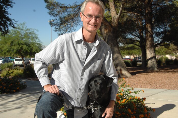 NELLIS AIR FORCE BASE, Nev.-- Christopher Sellman and his guide dog, Obi, stop for a picture at Nellis.  After losing his sight due to a number of medical emergencies, Mr. Sellman received Obi from Guide Dogs of America, one of the many Combined Federal Campaign charities people can contribute to during this year’s campaign. (U.S. Air Force photo by Senior Airman Michael Charles)