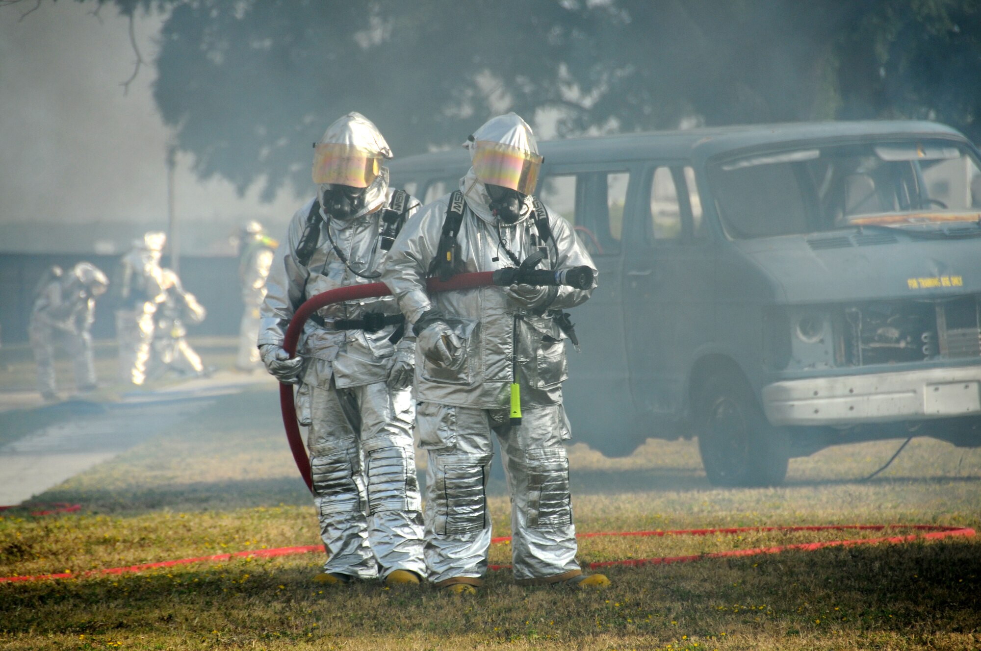 Keesler firefighters respond on scene in Tuesday's major accident response exercise.  During the exercise a C-130J made a hard landing, lost engine power and crashed into a six-passenger van, coming to rest on the Triangle track north of Alho Manor.  The scenario also included a spill from chemicals on the aircraft, hydraulic fluid and JP-8 fuel.  Three people "died" and 30 were "injured" in the accident, part of this week's Air Education and Training Command Compliance Inspection.  (U.S. Air Force photo by Kemberly Groue)
