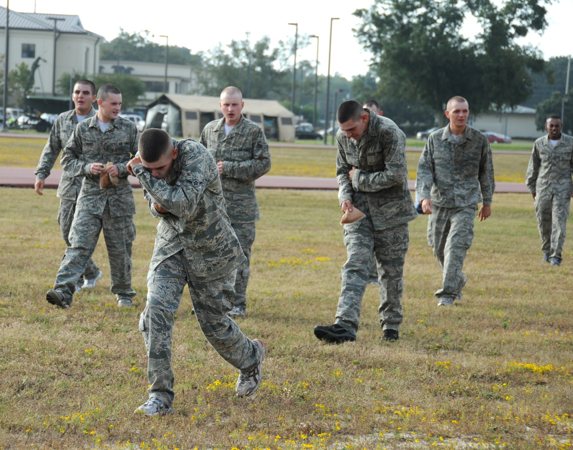 Nico Spadafora, a 334th Training Squadron student leads other students towards responding firefighters as they arrive on scene.  The airmen were affected by the chemicals released from the aircraft in Tuesday's major accident response exercise.  During the exercise a C-130J made a hard landing, lost engine power and crashed into a six-passenger van, coming to rest on the Triangle track north of Alho Manor.  The scenario also included a spill from chemicals on the aircraft, hydraulic fluid and JP-8 fuel.  Three people "died" and 30 were "injured" in the accident, part of this week's Air Education and Training Command Compliance Inspection.  (U.S. Air Force photo by Kemberly Groue)