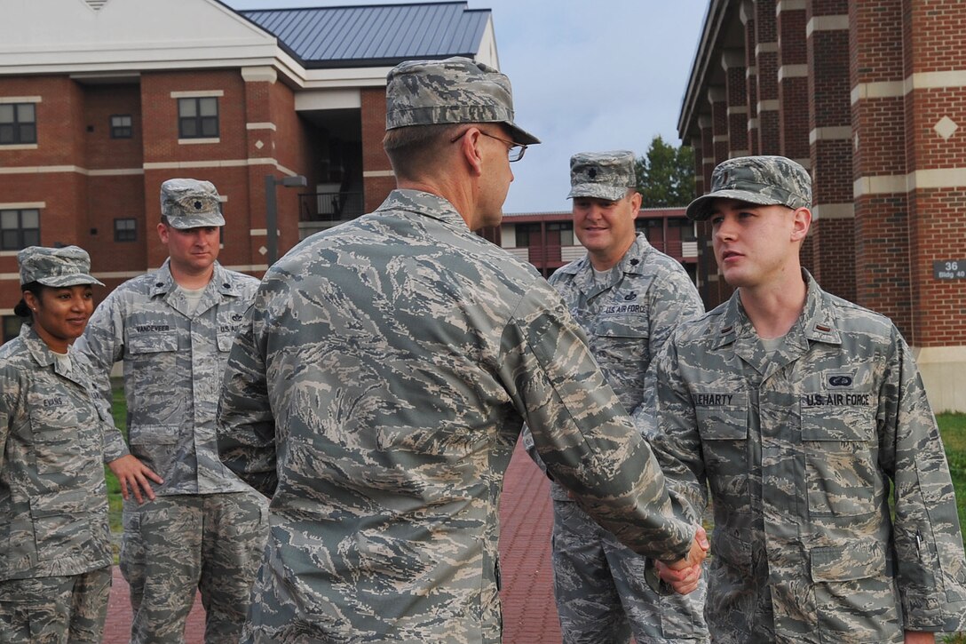 LANGLEY AIR FORCE BASE, Va. -- Maj. Gen. Stephen L. Hoog, 9th Air Force, commander, coins 2nd Lt. Matthew Fleharty, 633d Air Base Wing Contracting Squadron contracting manager, for his contributions to the new dorms while visiting the base Oct. 26. General Hoog toured the entire base, as well as Fort Eustis, to gain greater knowledge on the Airmen, Soldiers and improvement projects across both installations. (U.S. Air Force photo/Staff Sgt. Ashley Hawkins)(RELEASED)