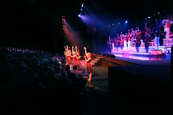Tops In Blue entertainers line the stage during a performance at the North Charleston Performing Arts Center Oct. 21, 2010. The members of Tops In Blue must complete a highly accelerated educational process to prepare them to succeed as world class entertainers during their nine month tour. Some of the performers' responsibilities include setting up the stage, lighting, audio and special effects equipment. They must learn to work as a self-contained operational unit that can manage their own lodging, transportation, dining and wardrobe. (U.S. Air Force Photo/Airman 1st Class Lauren Main)