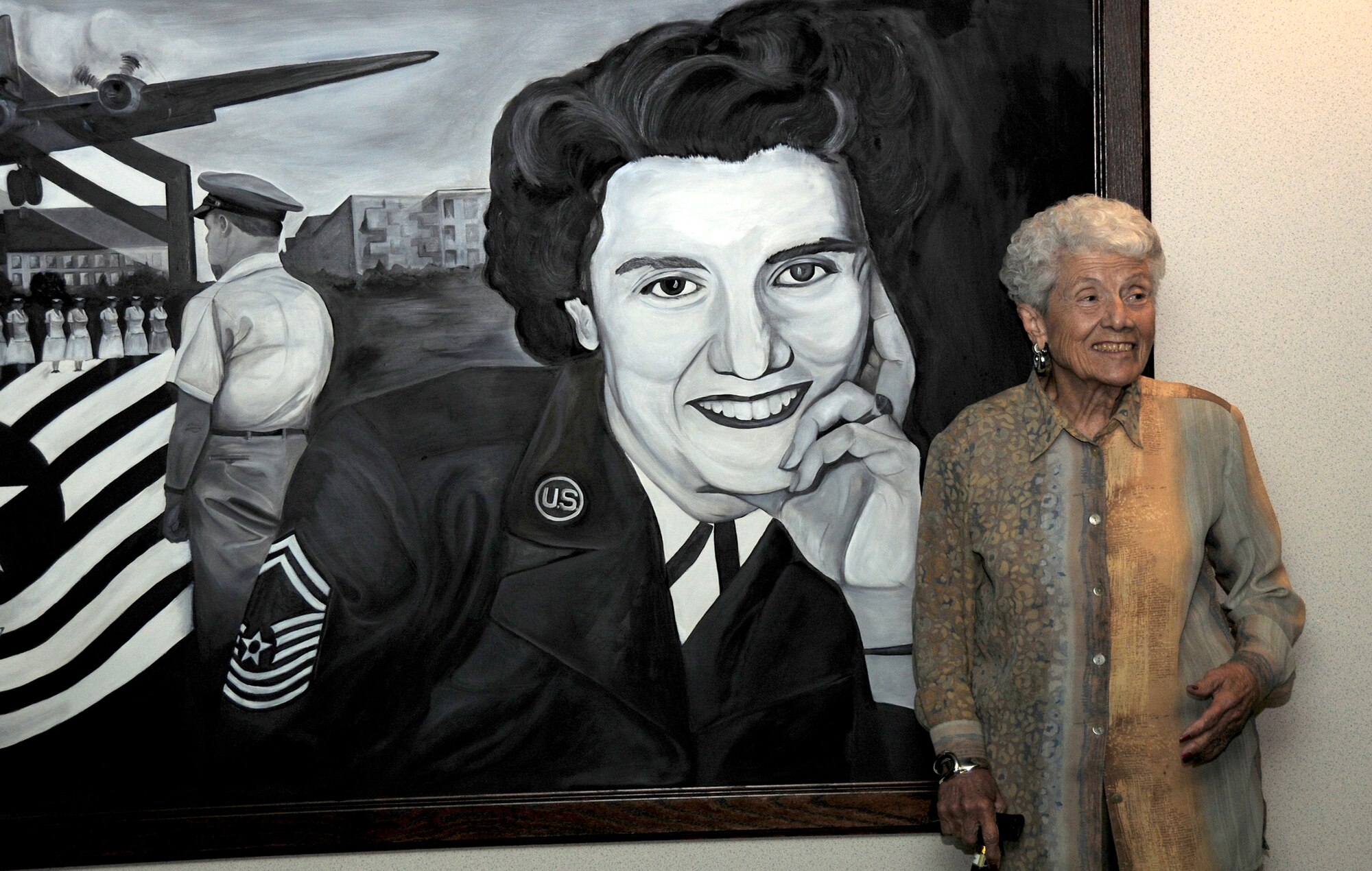 Retired Chief Master Sgt. Grace Peterson stands in front of a painting of herself in front of the Grace Peterson Hall at the U.S. Air Force Expeditionary Center Oct. 18, 2010, at Joint Base McGuire-Dix-Lakehurst, N.J. Chief Peterson was the first female Airman to be promoted to the Air Force's highest enlisted grade in 1960. She visited the U.S. Air Force Expeditionary Center to see the facility and the hall that bears her name. (U.S. Air Force photo/Staff Sgt. Veuril McDavid)
