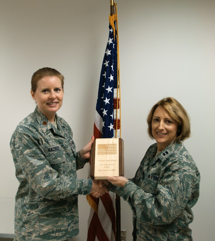 Maj. Kristine Hackett (left) presents Capt. Marion Collins with the Association of Women's Health, Obstetric and Neonatal Nurses Armed Forces Section's 2010 Junior Nurse of the Year award at the 633rd Medical Group women's health clinic. Captain Collins won the award during the AWHONN annual conference in Las Vegas for her dedicated body of work as an Air Force nurse. Major Hackett is the 633rd MG women's health clinic flight commander and Captain Collins is the women's health clinic nurse manager. (U.S. Air Force photo/Airman 1st Class Jason Brown)