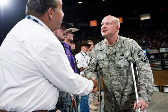 LAS VEGAS --  Master Sgt. Jeramie Brown, 99th Air Base Wing Public Affairs broadcast journalist, shakes hands with professional bull riders at the Professional Bull Riding Finals in the Thomas and Mack Center Oct. 22. Airmen from Nellis Air Force Base were honored for their service to the country during Air Force night at the PBR Finals.  (U.S. Air Force photo / Tech. Sgt. Michael R. Holzworth)
