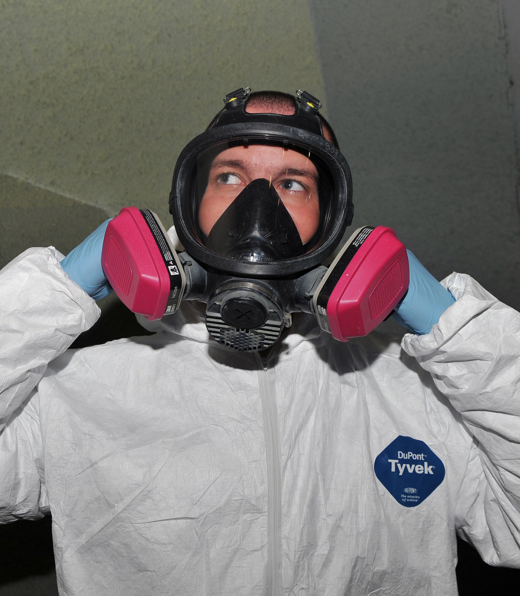 Senior Airman Dakota Phillips, 19th Equipment Maintenance Squadron corrosion control journeyman, dons his personal protective equipment Oct. 22. Individuals performing corrosion control must wear a Tyvek suit, full-face respirator and other personal protection equipment. (U.S. Air Force photo by Senior Airman Gul Crockett)