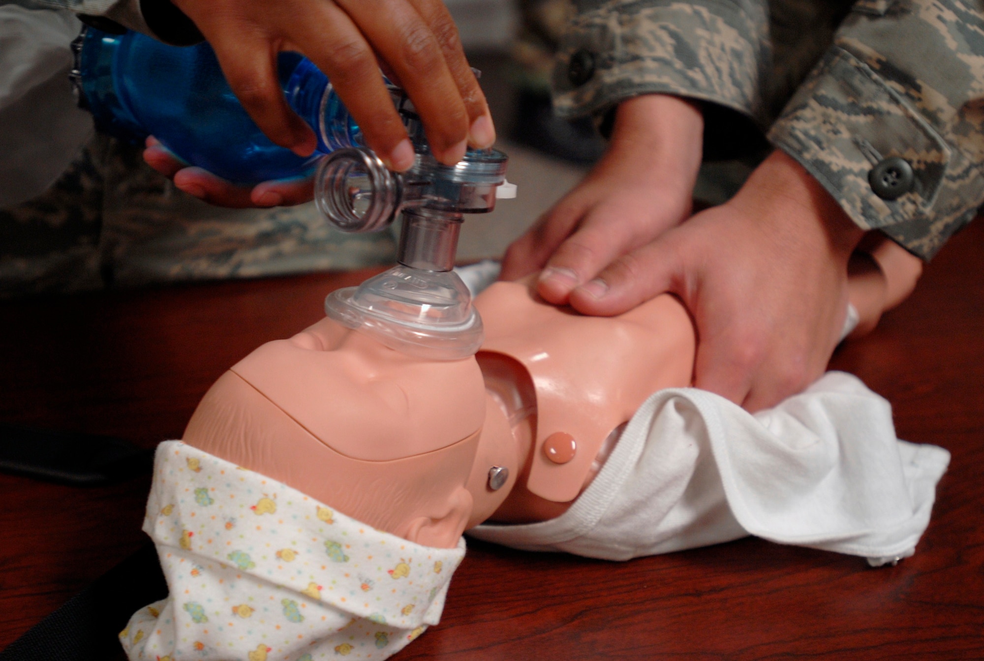 Airmen practice an alternate form of cardiopulmonary resuscitation for infants, which is different than the two-finger chest compression that is typically taught to students. (U.S. Air Force photo/Airman 1st Class Jessica Hines)