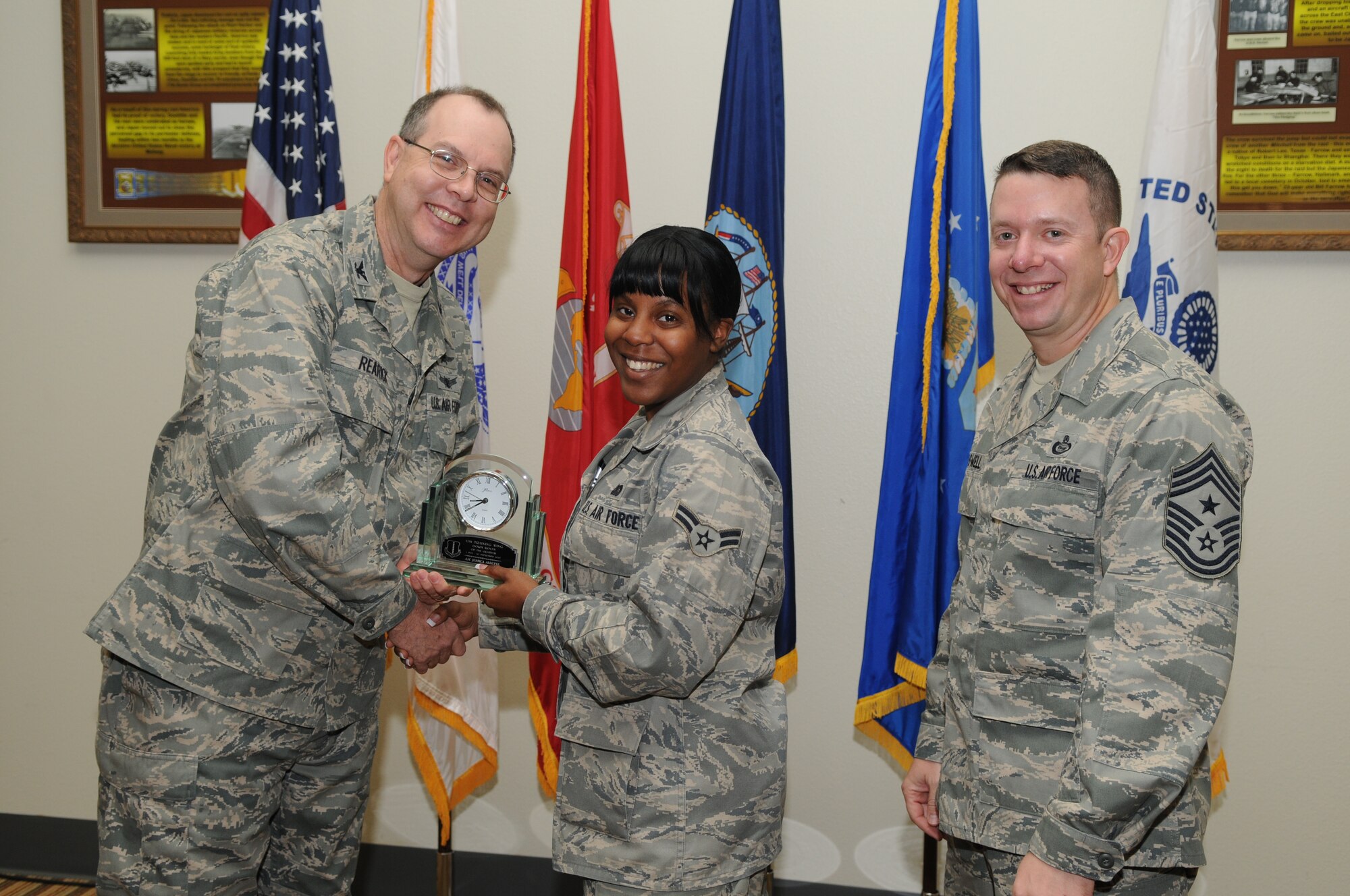 GOODFELLOW AIR FORCE BASE, Texas -- Airman 1st Class Jessica Alleyne, 17th Training Wing , accepts her Dorm Room of the Quarter Award for the third quarter from Col. David Rearick, 17th Training Wing Vice Commander, and Chief Master Sgt. Brendan Criswell, 17th TRW Command Chief, during the awards breakfast Oct. 26. (U.S. Air Force photo/Airman 1st Class Clayton Lenhardt)