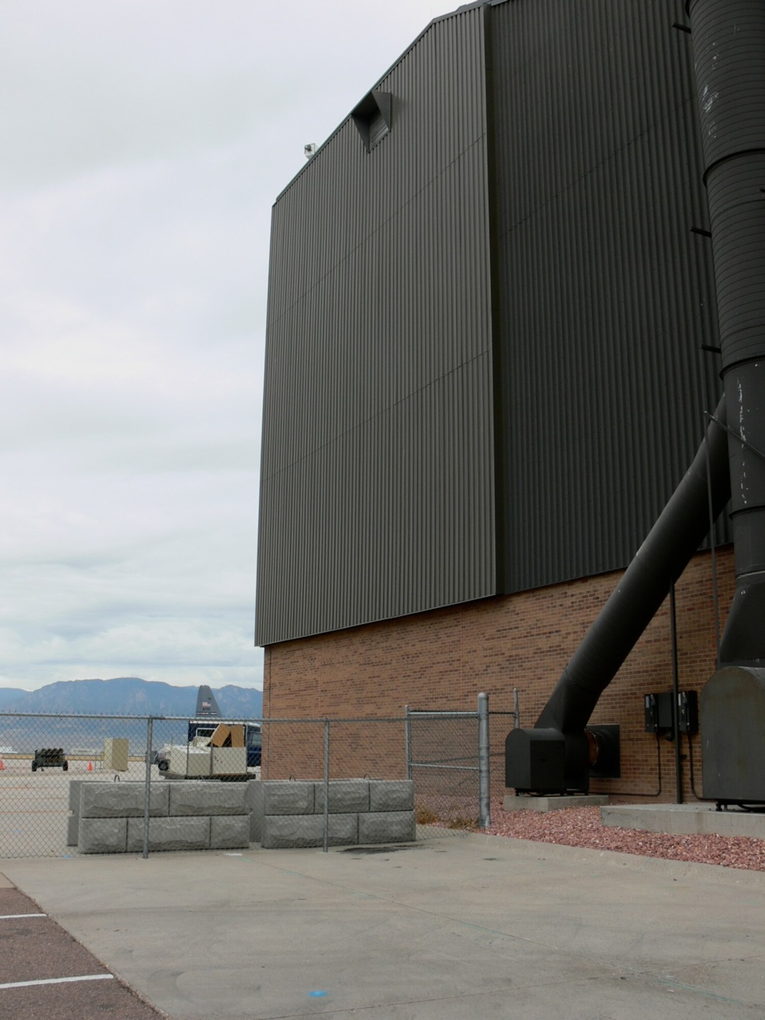 A solar wall was installed on Hangar 210 on Peterson Air Force Base in 2007. The wall is made of ribbed panels that have small slits on them. Air is drawn in through the slits and the surface of the panels heats the air, which is then blown in through an air duct inside the hangar. To date, the project has saved $126,000 in utility costs. Solar walls are being considered for other buildings on base in an effort to increase renewable energy sources. (U.S. Air Force photo/Monica Mendoza) 