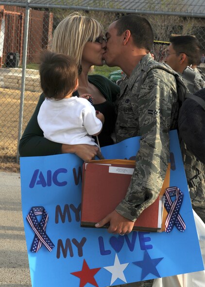 DYESS AIR FORCE BASE, Texas-- Airman 1st Class Seth Wilkinson, 317 Aircraft Maintenance Squadron electronic warfare technician, reunites with his wife Ashley and their one-year-old son Gavin Oct. 22 during a deployment return here. The 317 AMXS deployed in support of Operation Enduring Freedom, Operation New Dawn and Joint Task Force Horn of Africa. (U.S. Air Force photo/ Senior Airman Felicia Juenke)