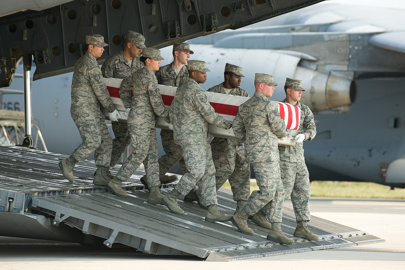 A U.S. Air Force carry team transfers the remains of an Airman at Dover Air Force Base, Del. Carry teams are comprised of personnel from the services career field who deploy to Air Force Mortuary Operations. Recently, personnel from other career fields were included in the tasking. Staff Sgt. Chris Hill (front left), a computer programmer, Airman 1st Class Matthew Bokesch (front right), a public health technician and Staff Sgt. Rachel Gamertsfelder-Doane (third on the left), security forces took part in the sacred mission of honoring the fallen with dignity, honor and respect. (U.S. Air Force photo/Jason Minto)