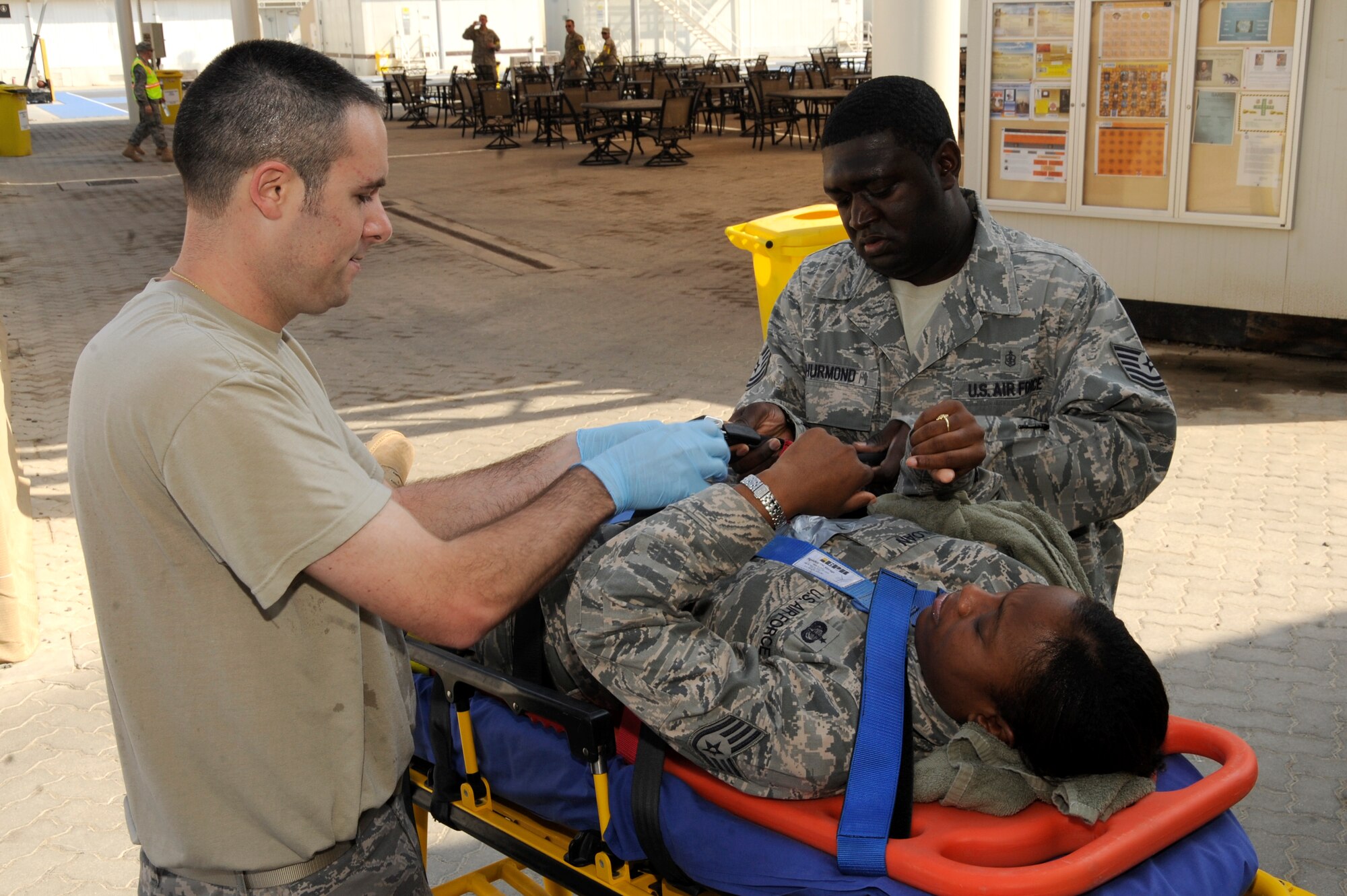 (Left) Staff Sgt. Benjamin Bates and (right) Tech. Sgt. Hubert Thurmond,
380th Expeditionary Medical Group medical technicians, help a simulated
victim during an exercise Oct. 23, 2010, at an undisclosed location in
Southwest Asia. Airmen from the 380th Air Expeditionary Wing practiced how
to respond to an active shooter during the exercise. (U.S. Air Force
photo/Tech. Sgt. April Wickes) 
