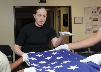 Randolph AFB, TX,25/10/2010: Staff Sgt Carla Rutledge instructs Randolph Honor Guard members on proper flag folding for official ceremonies, during practice at the Honor Guard Shack. SSgt. Rutledge is a management analyst with the 1 MRS 
(U.S. Air Force photo/David Terry)