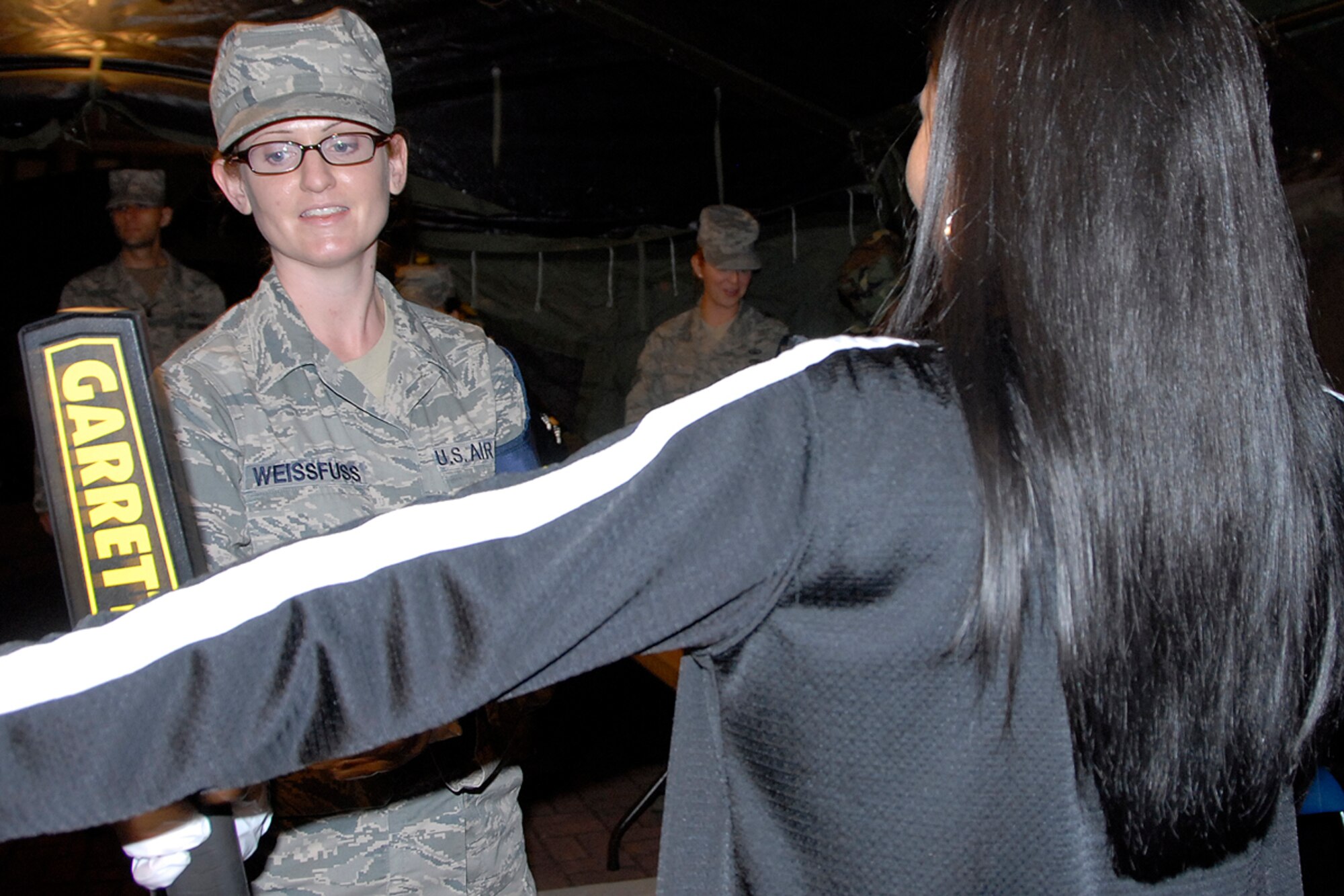 Staff Sgt. Jessica Weissfuss, 731st Air Mobility Squadron, searches a woman at Osan Air Base, Republic of Korea Oct. 22. The search was apart of an annual Non-combatant Evacuation Operation exercise. The two-day exercise tested the base's ability to process and evacuate non-combatant base personnel and dependents in the event of an emergency. (U.S. Air Force photo/Staff Sgt. Eunique Stevens)   