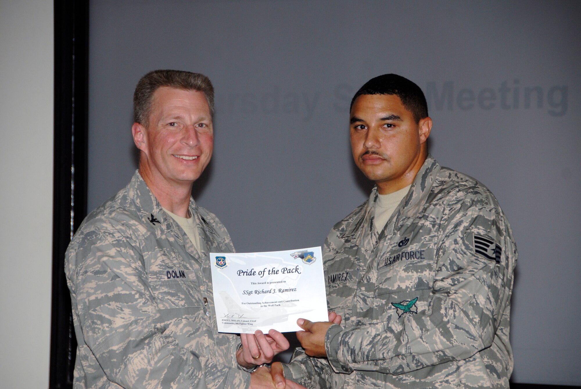 KUNSAN AIR BASE, Republic of Korea -- Col. John Dolan, 8th Fighter Wing commander, presents Staff Sgt. Richard Ramirez, 8th Civil Engineer Squadron, with a Pride of the Pack award Oct. 21. (U.S. Air Force photo/Capt. Sheryll Klinkel)