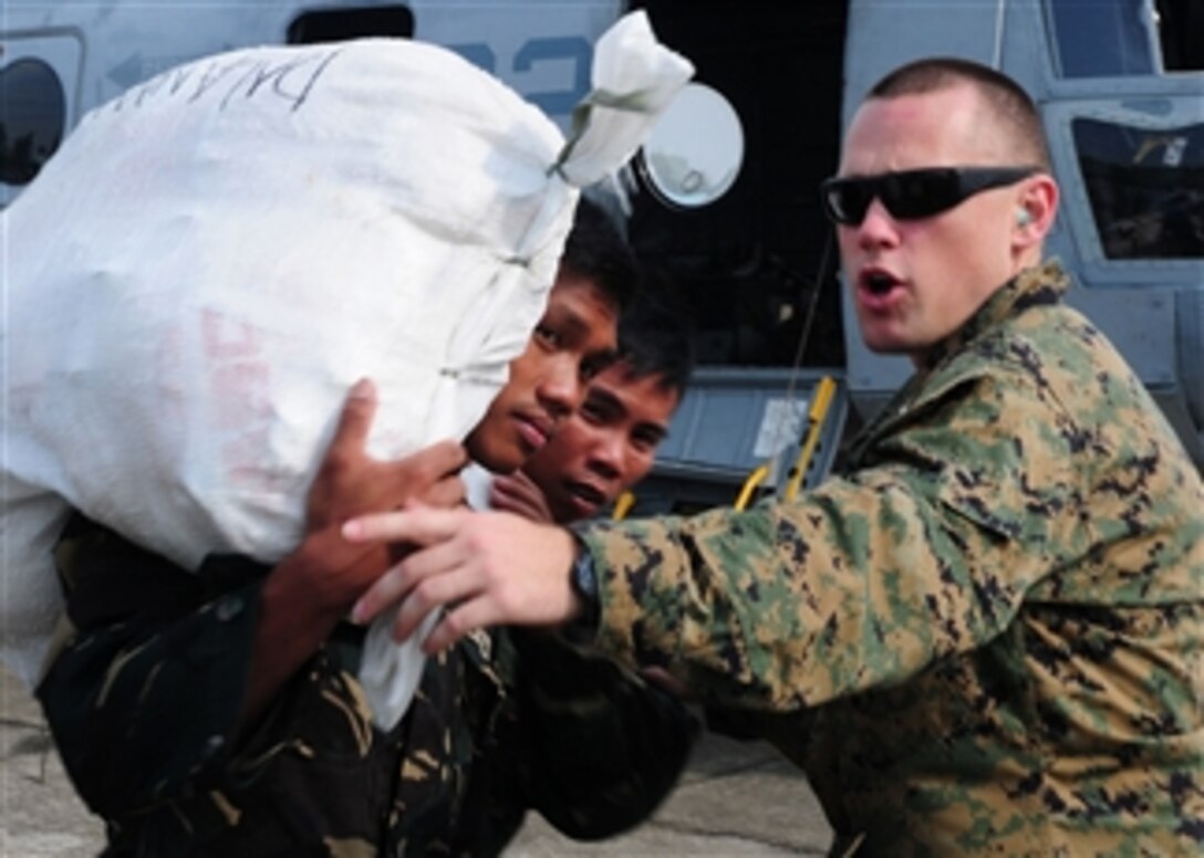 U.S. Marine Corps Capt. Bill Woodward, from the 31st Marine Expeditionary Unit, directs Philippine service members while loading supplies into a CH-46E Sea Knight helicopter assigned to Marine Medium Helicopter Squadron 262 in the Philippines on Oct. 22, 2010.  Marines with the 31st Marine Expeditionary Unit are assisting the Philippine government with assessment of damage caused by the Typhoon Megi, which is also known locally as Typhoon Juan.  