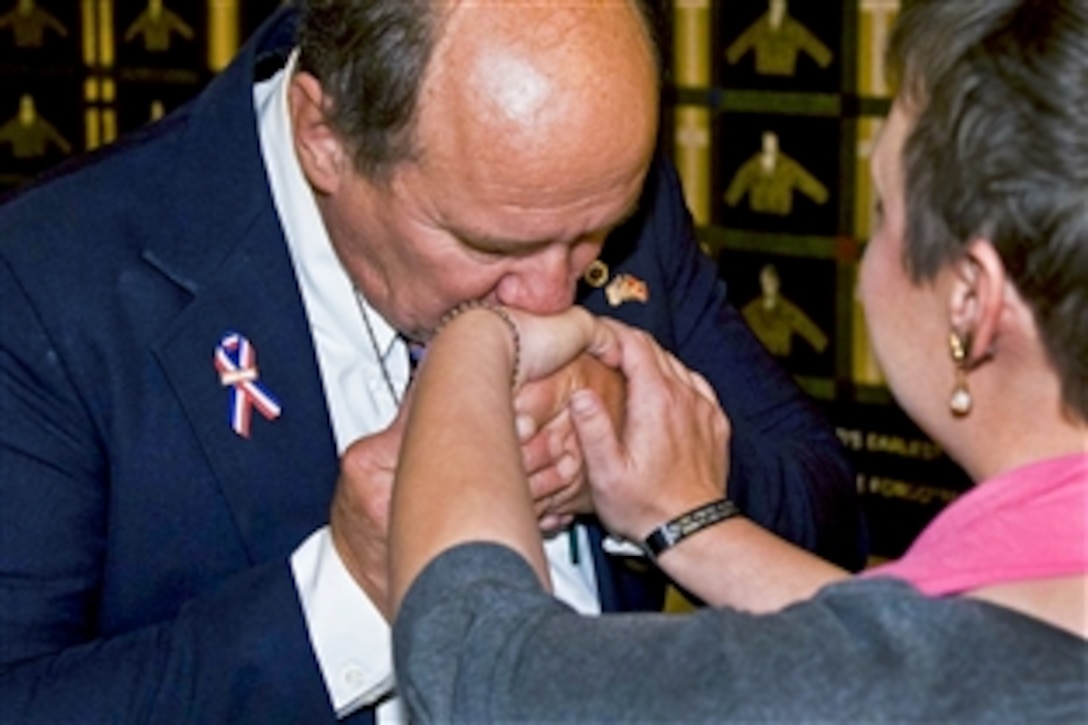 Greg Thompson, left, father of U.S. Marine Corps. Cpl. Lance Thompson, kisses the hand of a "Gold Star" mother, a mother who has lost a child in Iraq or Afghanistan since 9/11, at the presentation of the Lost Heroes Art Quilt at the Indiana Capitol building in Indianapolis, Oct. 25, 2010. Cpl. Thompson was killed in action in Al Anbar province, Iraq, Nov. 15, 2004.