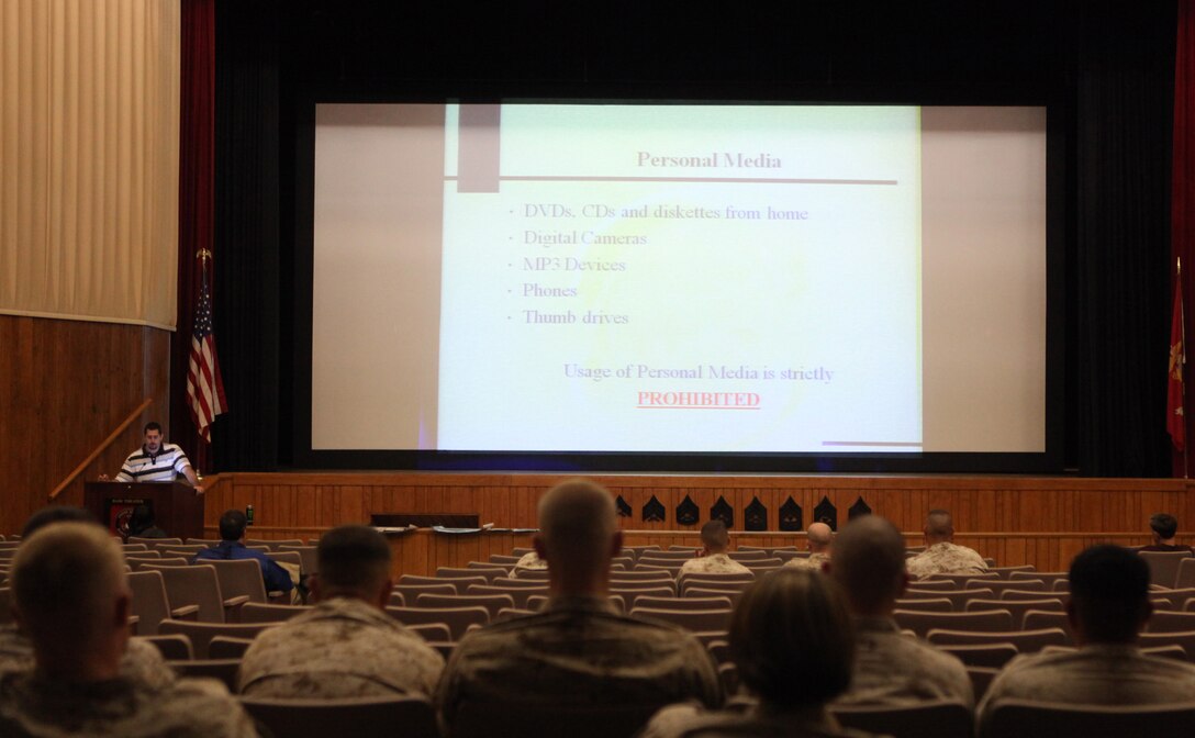 Service members and Department of Defense employees read a slide about personal media during an information assurance training class at the base theater aboard Marine Corps Base Camp Lejeune, recently.  IA training is conducted annually and is required per Marine Corps Base Order 5239.2 for everyone who has access to the government network.