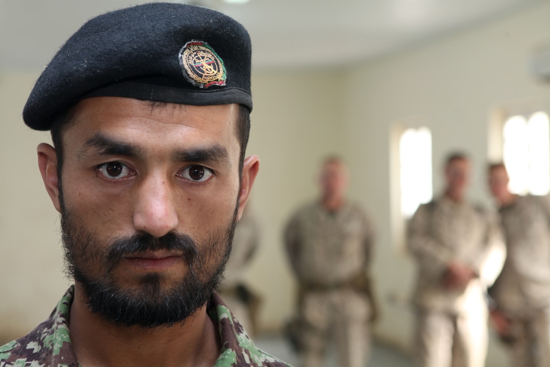 Afghan National Army Staff Sgt. Dost Mohammad eagerly awaits his ANA instructor course diploma during the first ANA instructor course graduation ceremony at Camp Dwyer, Oct. 27.