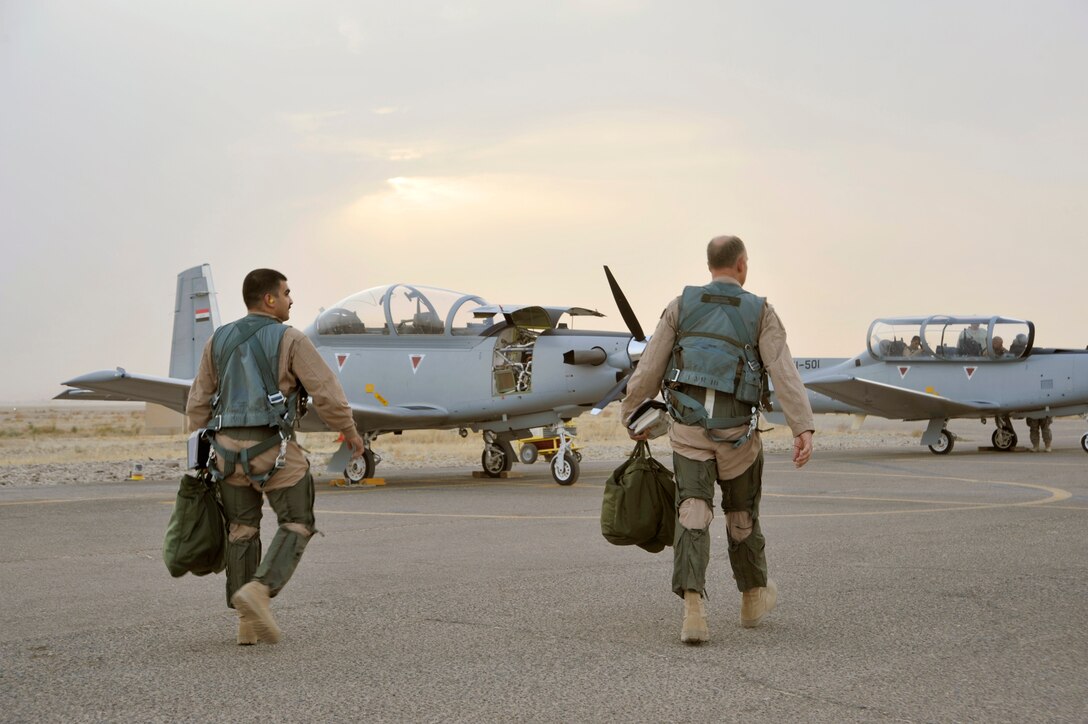 Maj. Thomas Bernard and an Iraq air force student pilot walk to their aircraft before a training flight Sept. 26, 2010, at Tikrit Air Base, Iraq. U.S. Air Force instructor pilots are training and advising the first group of Iraqi air force instructor pilots on the T-6A Texan II as part of the advise, train, assist and equip mission of Operation New Dawn. Once qualified the Iraqi air force pilots will become instructor pilots and continue to train the next generation of pilots. Major Bernard is assigned to the 52nd Expeditionary Flying Training Squadron. (U.S. Air Force photo/Senior Airman Perry Aston)