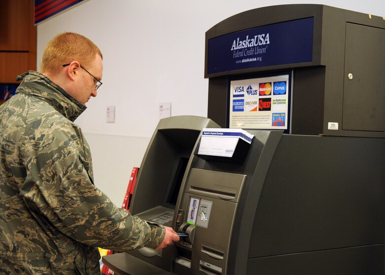 Staff Sgt. Christopher Tracy inserts a bank card into an ATM Oct. 26, 2010, at Eielson Air Force Base, Alaska. Scams include any trick used to gain information, money or resources by preying on a person. Sergeant Tracy is a 354th Communications Squadron network control center base equipment and custodian officer. (U.S. Air Force photo/Airman 1st Class Janine Thibault)
