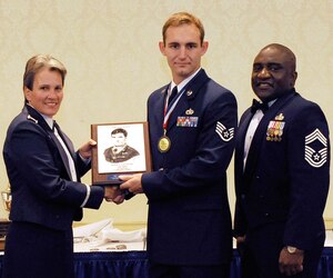 Col. Martha Meeker, left, and Chief Master Sgt. Thomas Jackson, right, present Staff Sgt. Chase Schexnayder with the John L. Levitow Award during the Airman Leadership School Class 10-G graduation at the Charleston Club on Joint Base Charleston-Air Base, S.C., Oct. 20, 2010. The award is given for a student's exemplary demonstration of excellence both as a leader and a scholar. Colonel Meeker is the 628th Air Base Wing commander, Chief Jackson is the 628th Mission Support Group chief enlisted manager, and Sergeant Schexnayder is an air transportation specialist with the 437th Aerial Port Squadron. (U.S. Air Force photo/Senior Airman Timothy Taylor)