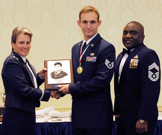 Col. Martha Meeker, left, and Chief Master Sgt. Thomas Jackson, right, present Staff Sgt. Chase Schexnayder with the John L. Levitow Award during the Airman Leadership School Class 10-G graduation at the Charleston Club on Joint Base Charleston-Air Base, S.C., Oct. 20, 2010. The award is given for a student's exemplary demonstration of excellence both as a leader and a scholar. Colonel Meeker is the 628th Air Base Wing commander, Chief Jackson is the 628th Mission Support Group chief enlisted manager, and Sergeant Schexnayder is an air transportation specialist with the 437th Aerial Port Squadron. (U.S. Air Force photo/Senior Airman Timothy Taylor)