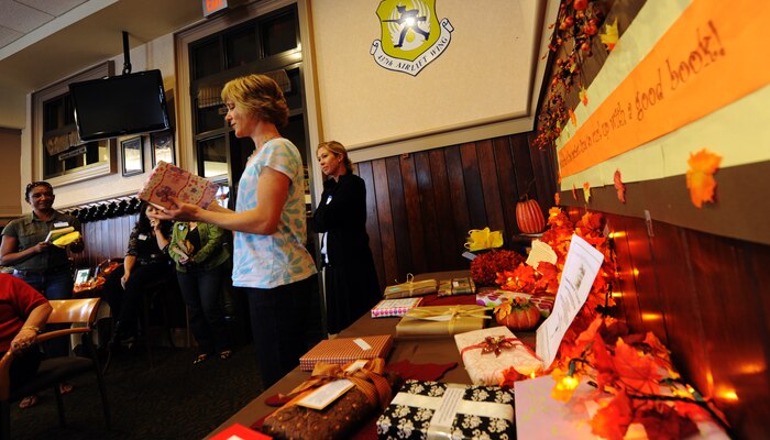 Linda Sanders reads a quote from a book aloud to fellow spouses during the Team Charleston Spouses' Club gathering at the Charleston Club Oct. 26, 2010, on Joint Base Charleston, S.C. The spouses' club also carries out "Meals for Moms." Meals for Moms is a program within the spouses' club that supports club members if they are hospitalized and need a home-cooked meal. Meals a prepared, vacuum sealed and frozen until needed. (U.S. Air Force photo/Senior Airman Timothy Taylor)